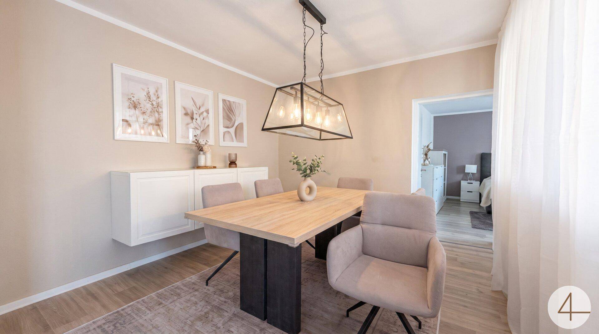 Moderner Essbereich mit Holztisch, Pendelleuchte und Zugang zum Schlafzimmer.