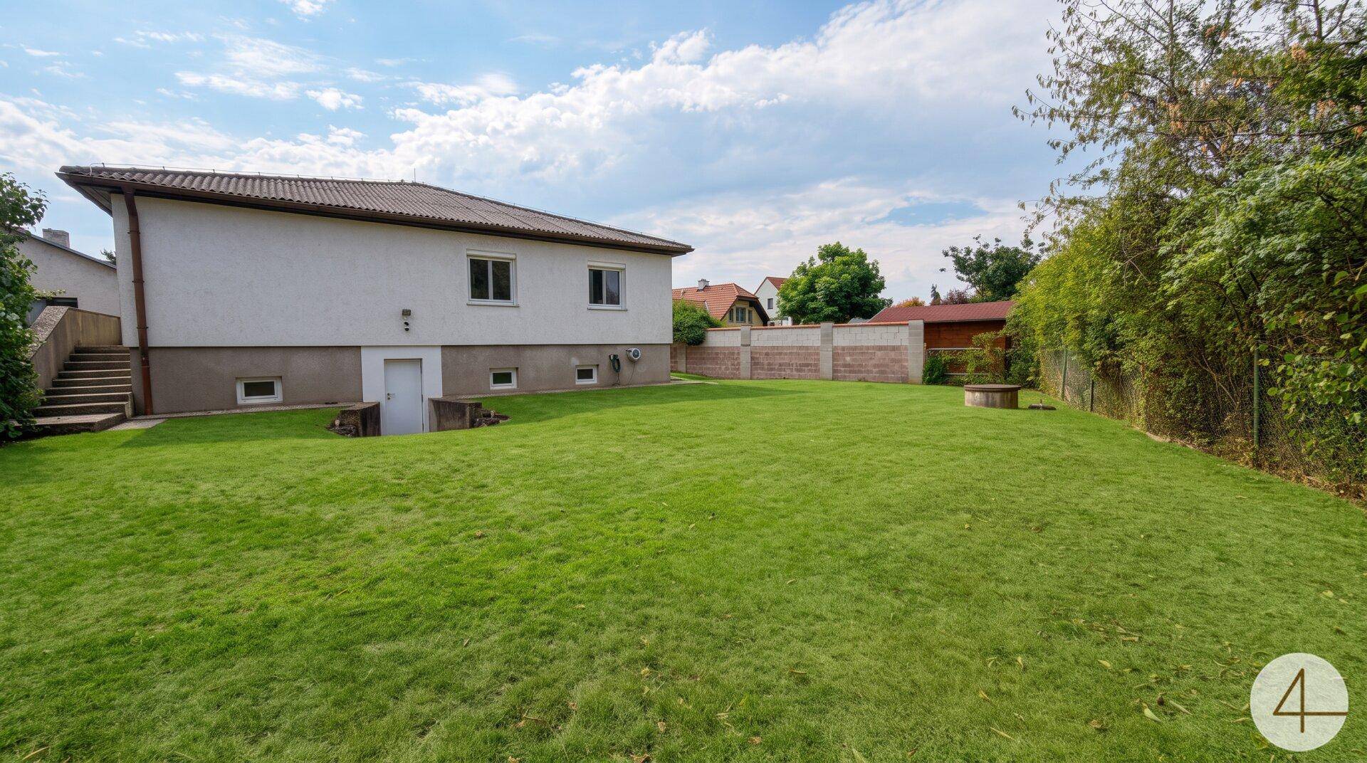 Großer, gepflegter Garten mit Rasenfläche und der Rückseite des Hauses.