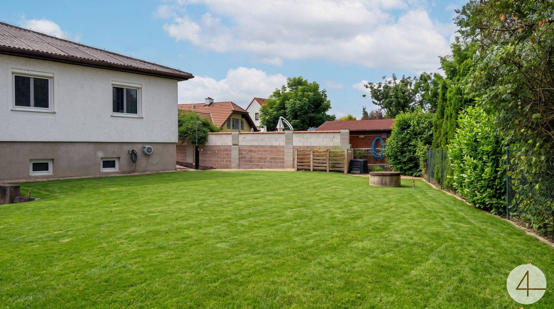 Weitläufiger Garten mit Rasenfläche, umzäuntem Bereich und der Rückseite des Hauses.