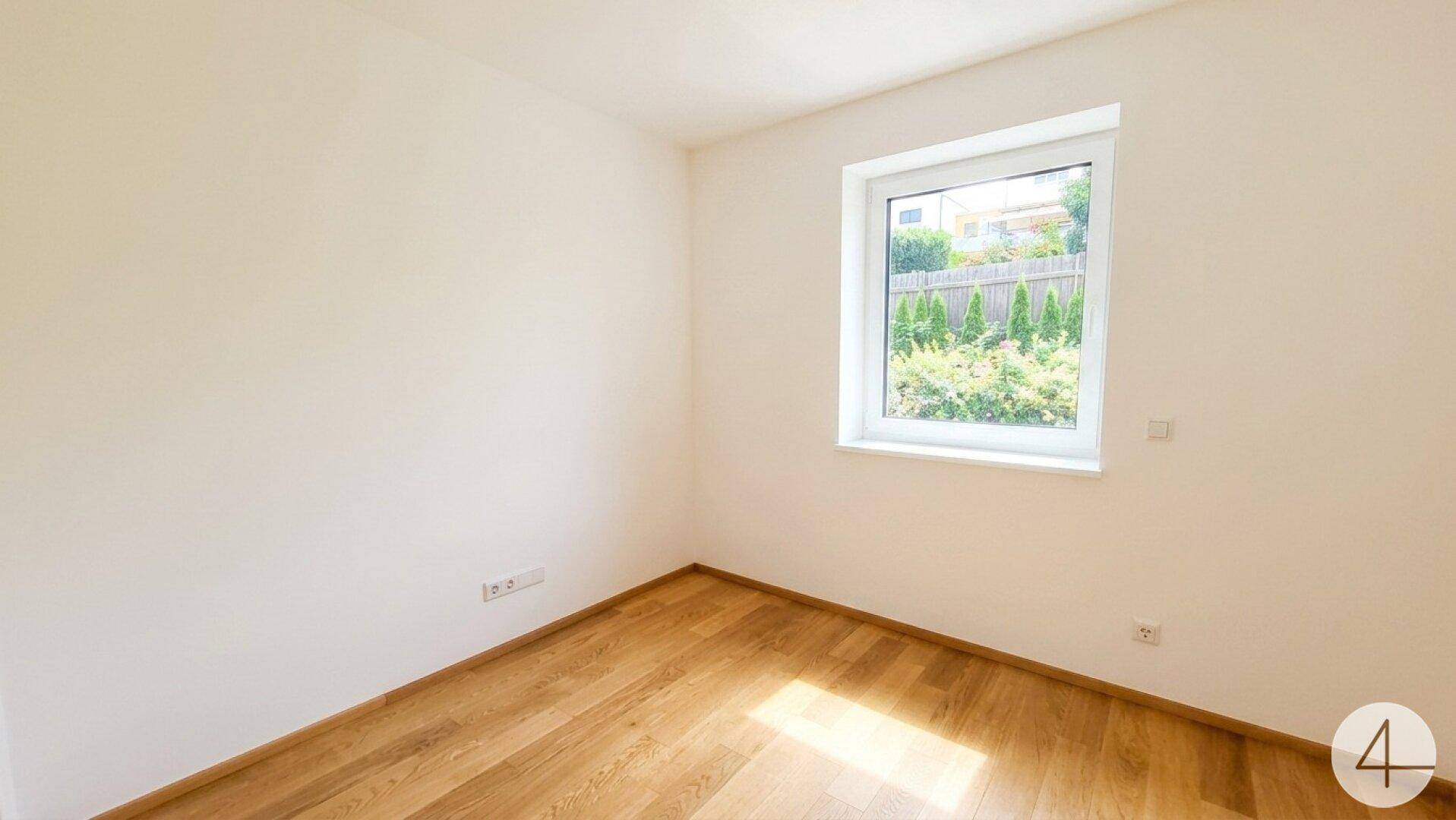 Helles Zimmer mit Holzboden und Fenster, ideal als Schlaf- oder Arbeitszimmer.