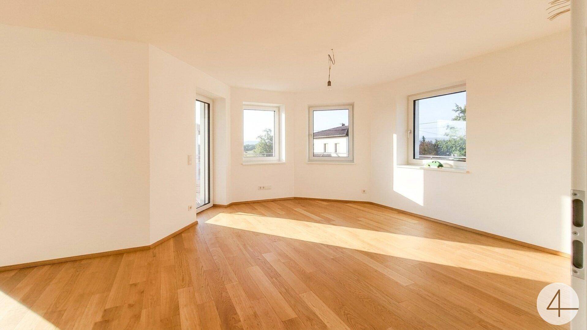 Lichtdurchfluteter Raum mit Holzboden und vielen Fenstern, ideal für individuelle Gestaltung.