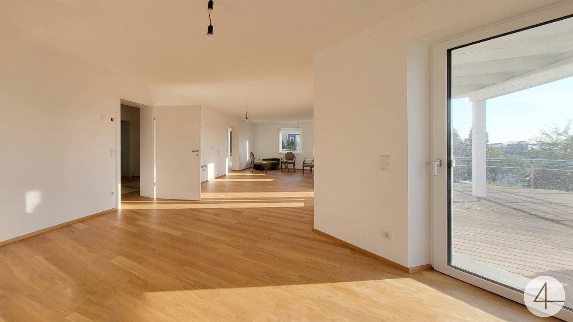 Großzügiger, heller Wohnbereich mit Holzboden und direktem Zugang zur Außenterrasse.