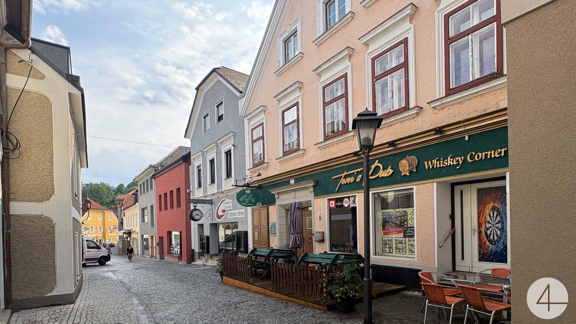 Malerische Gasse mit historischen Gebäuden, Kopfsteinpflaster und dem Pub "Toni's Pub" auf der rechten Seite.