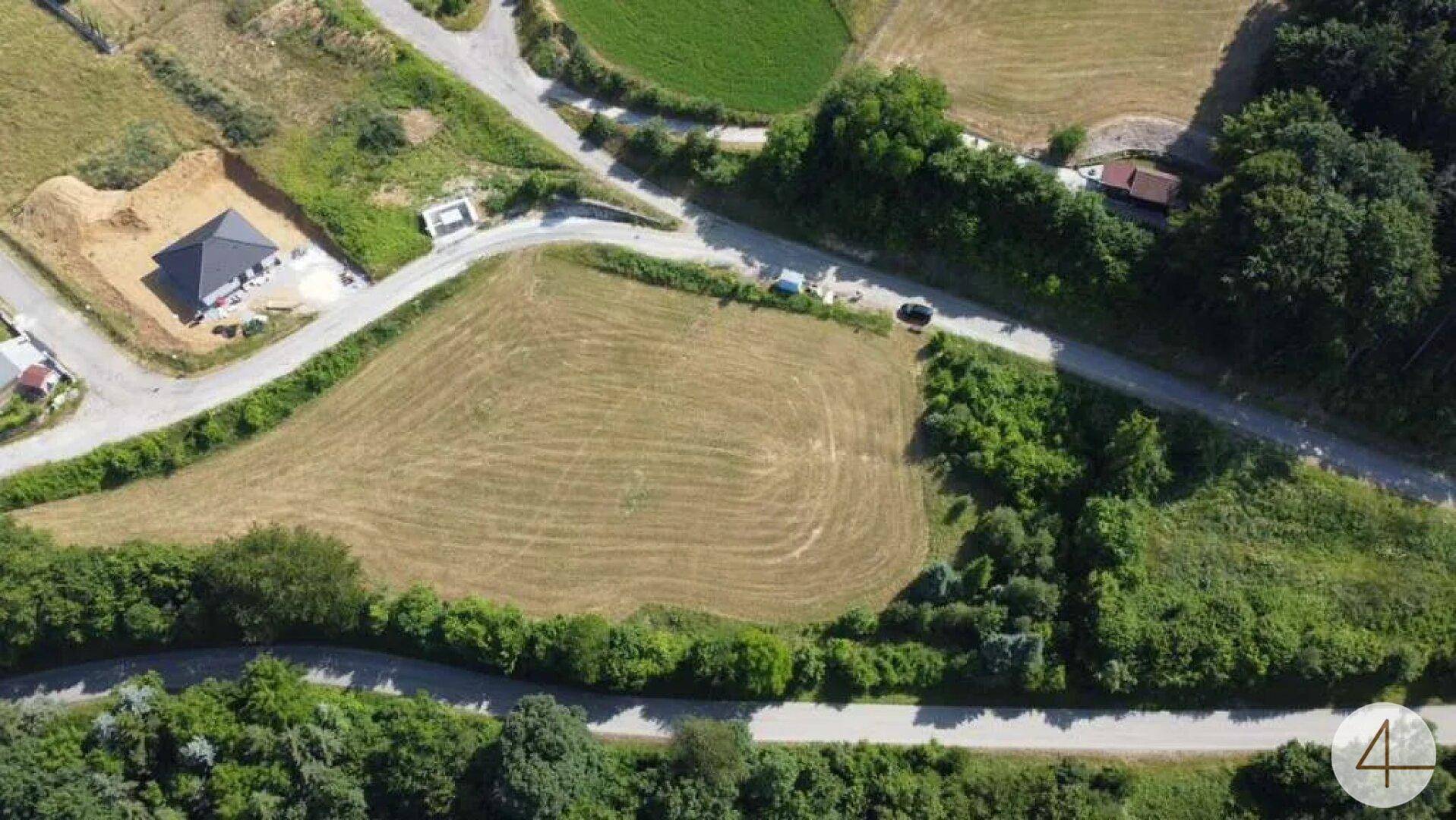 Luftaufnahme eines ländlichen Gebiets mit Straßen, Feldern und Neubauten.