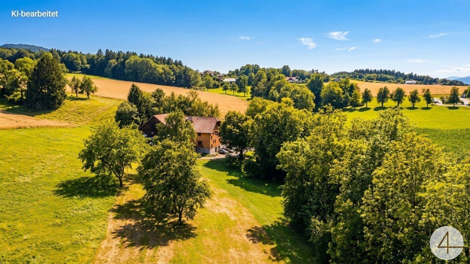 Panoramablick auf ein ländliches Anwesen, umgeben von Feldern und Wäldern.