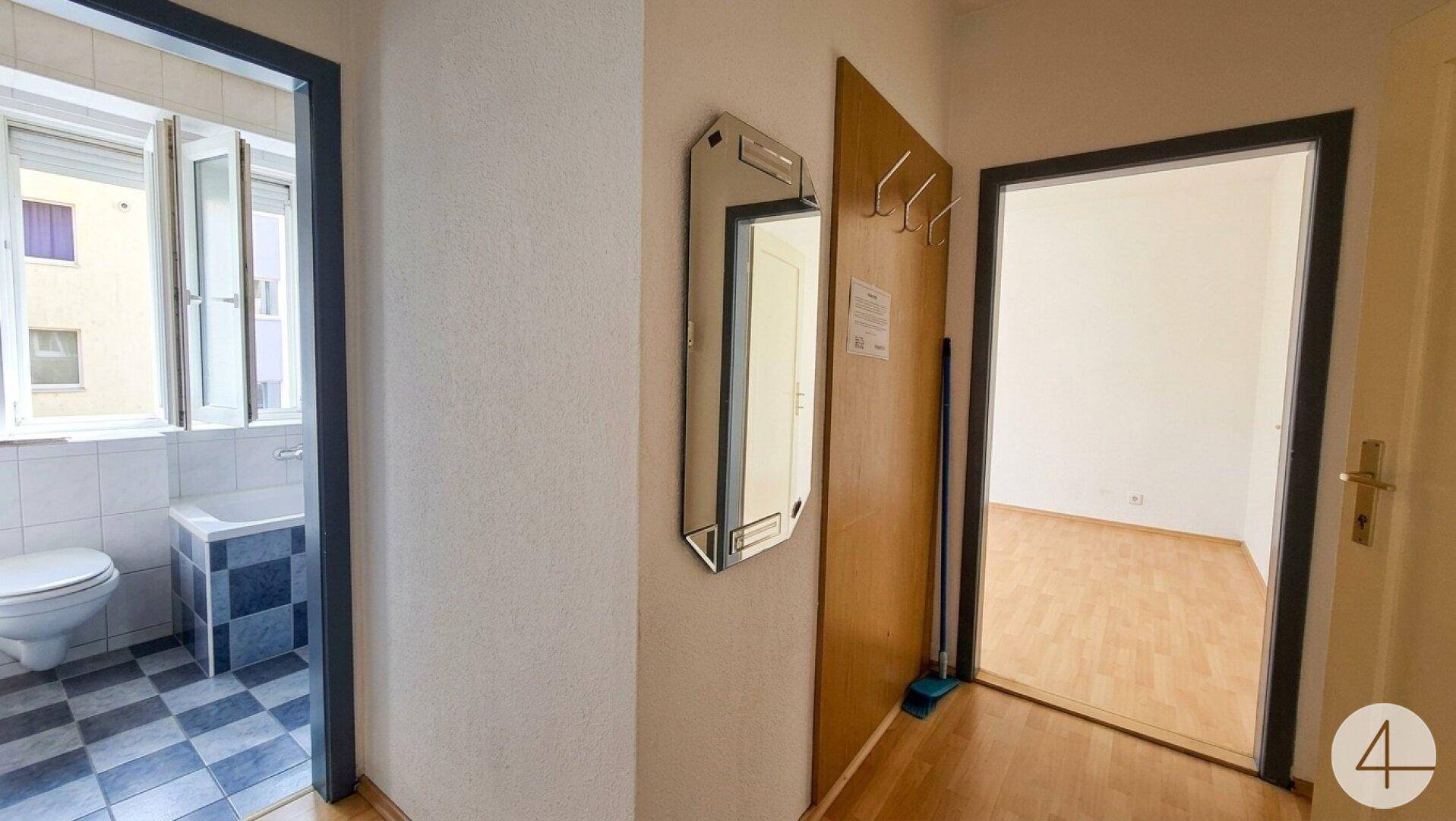Eingangsbereich mit Garderobe, Spiegel und Zugang zu weiteren Zimmern.