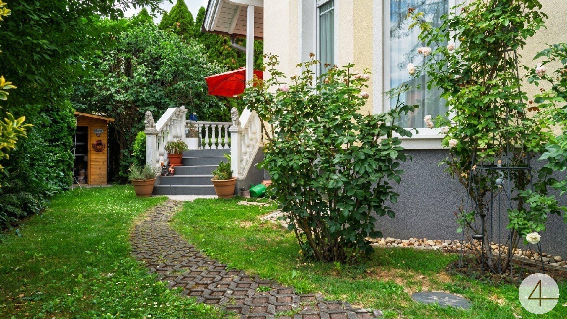 Gartenweg führt zu einem kleinen Geräteschuppen, umgeben von Rosenbüschen und Grünflächen.