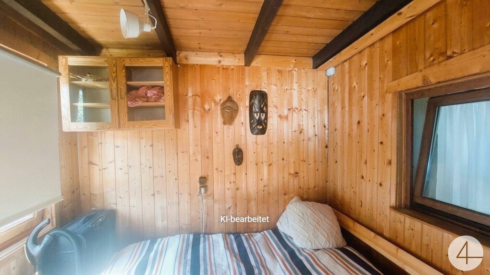 Kleines Schlafzimmer mit Holztäfelung, Einzelbett und rustikaler Einrichtung, hell beleuchtet.