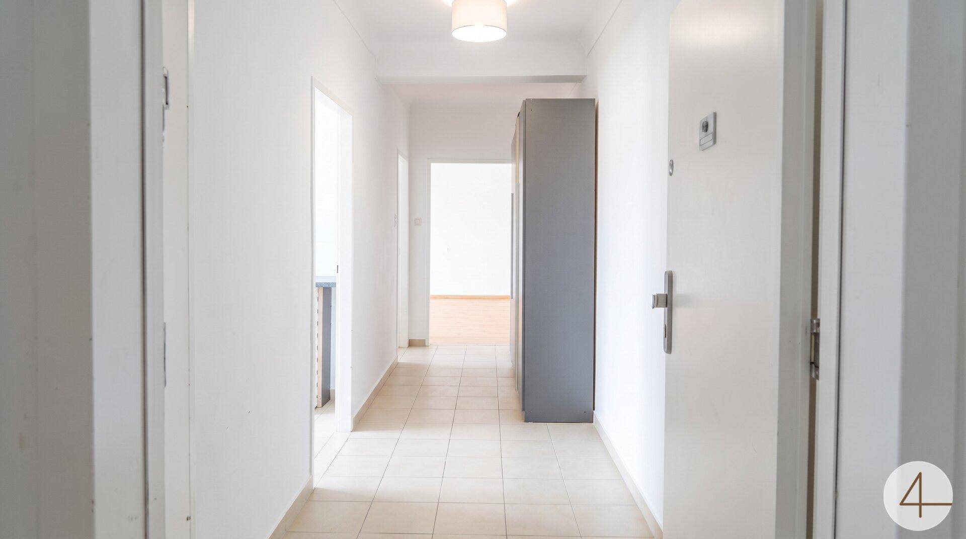 Geräumiger Flur mit hellen Fliesen und Zugang zu weiteren Zimmern der Wohnung.