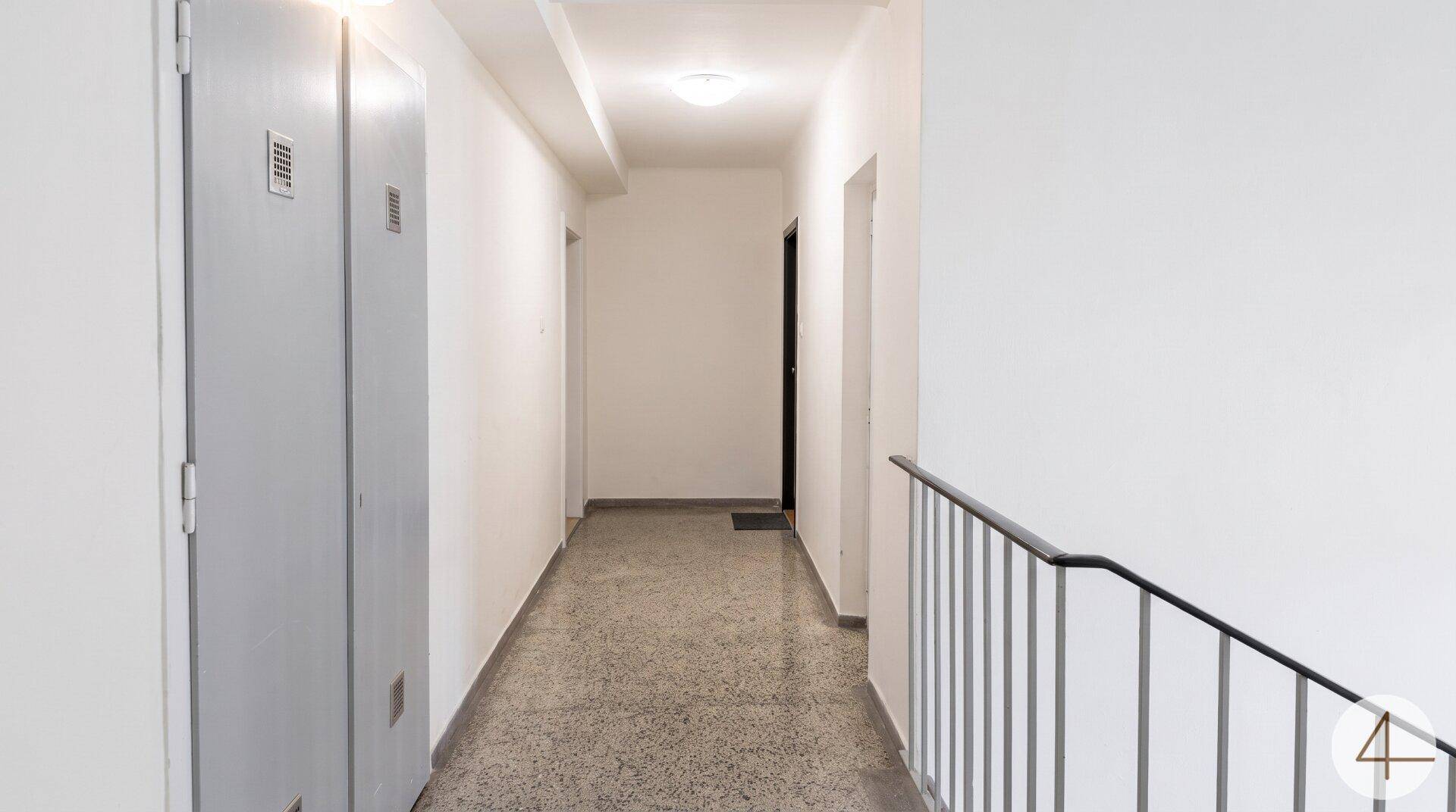 Heller Gemeinschaftsflur mit Aufzugzugang und Treppenhaus, gut gepflegt.