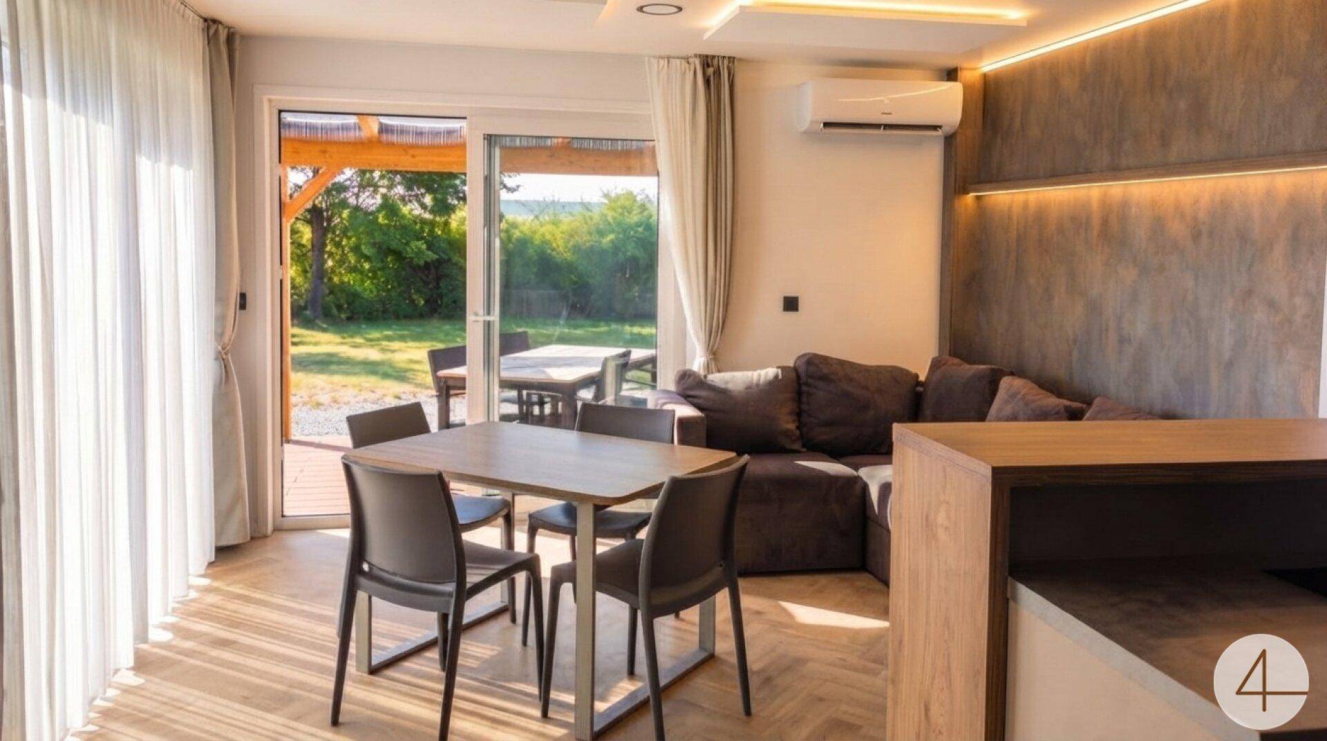 Heller Wohn- und Essbereich mit Zugang zur Terrasse, modernem Sofa und Klimaanlage.