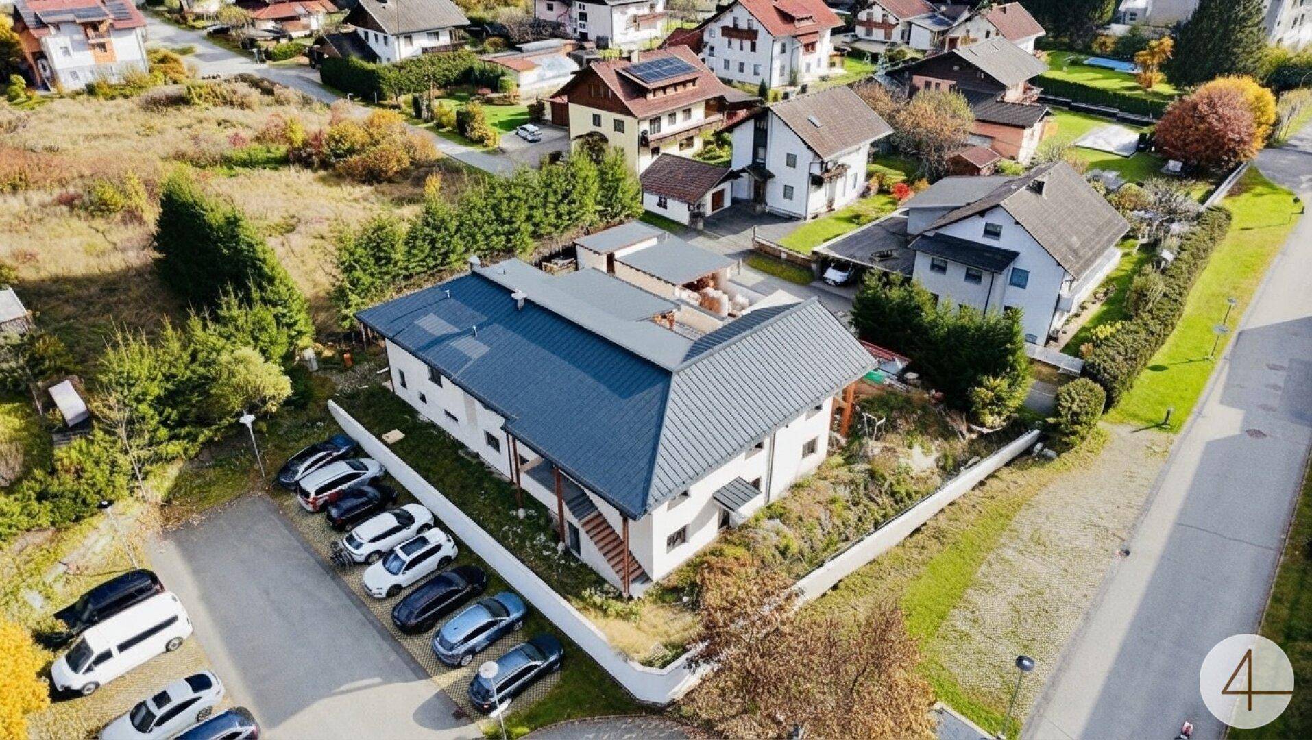 Überblick über das moderne Haus und die Nachbarschaft aus der Vogelperspektive, mit viel Grünfläche.