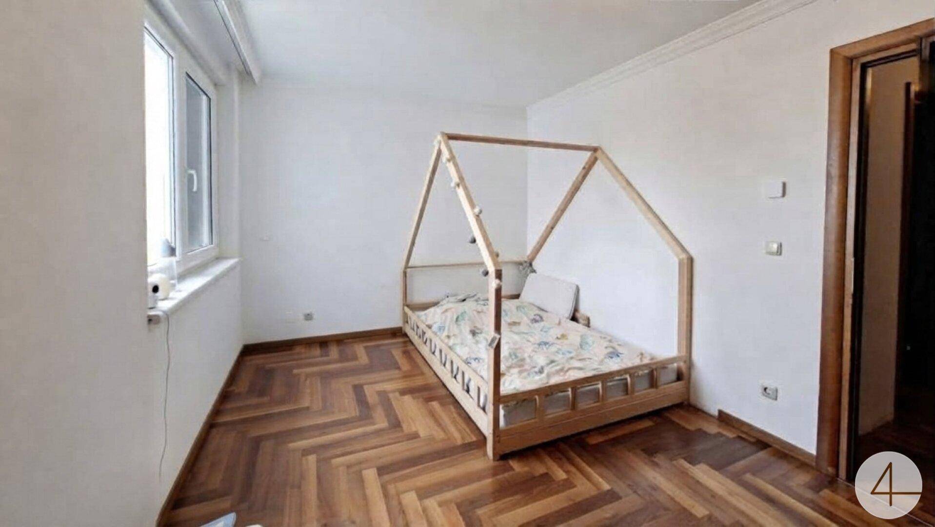 Kinderzimmer mit Fischgrätparkett und einem einzigartigen Hausbett aus Holz.