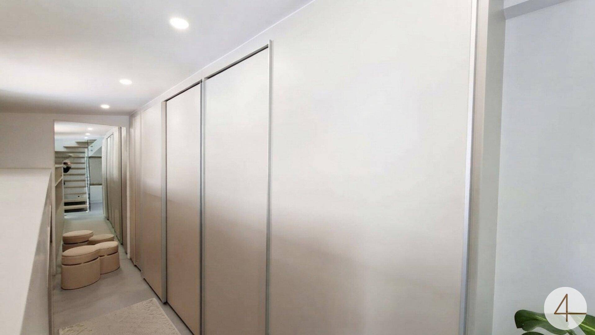 Heller Flur mit Einbauschränken und Zugang zu weiteren Räumen und einer Treppe.