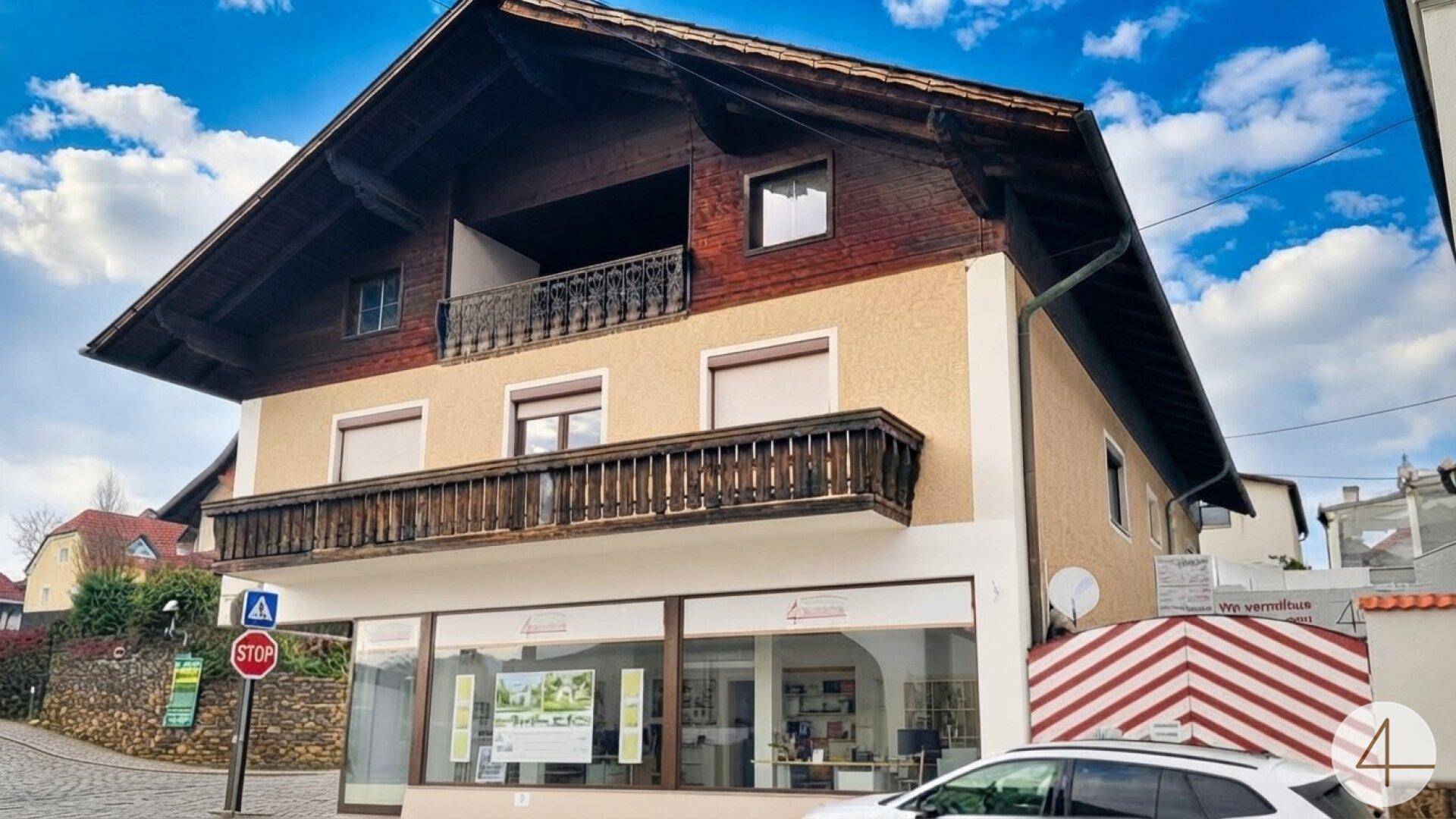 Traditionelles Gebäude mit Ladenlokal im Erdgeschoss und Holzbalkonen in den oberen Etagen.