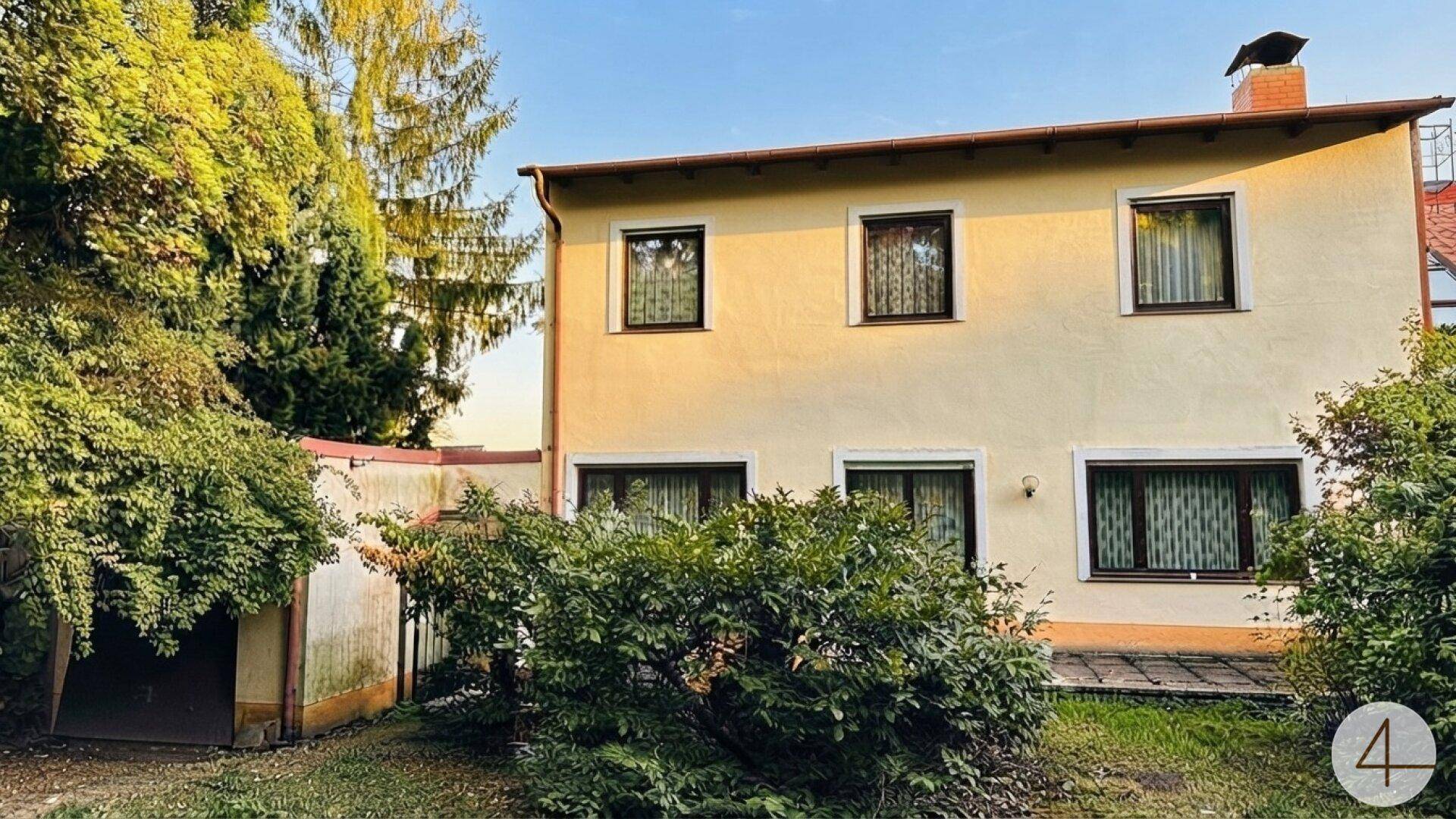 Rückansicht des Hauses mit gepflegtem Gartenbereich und üppiger Bepflanzung.