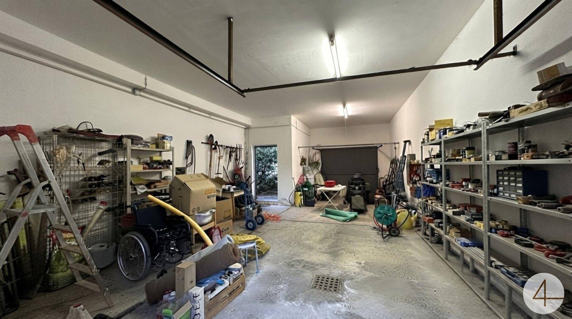 Geräumige Garage mit viel Stauraum, Werkzeugen und direktem Zugang nach draußen.