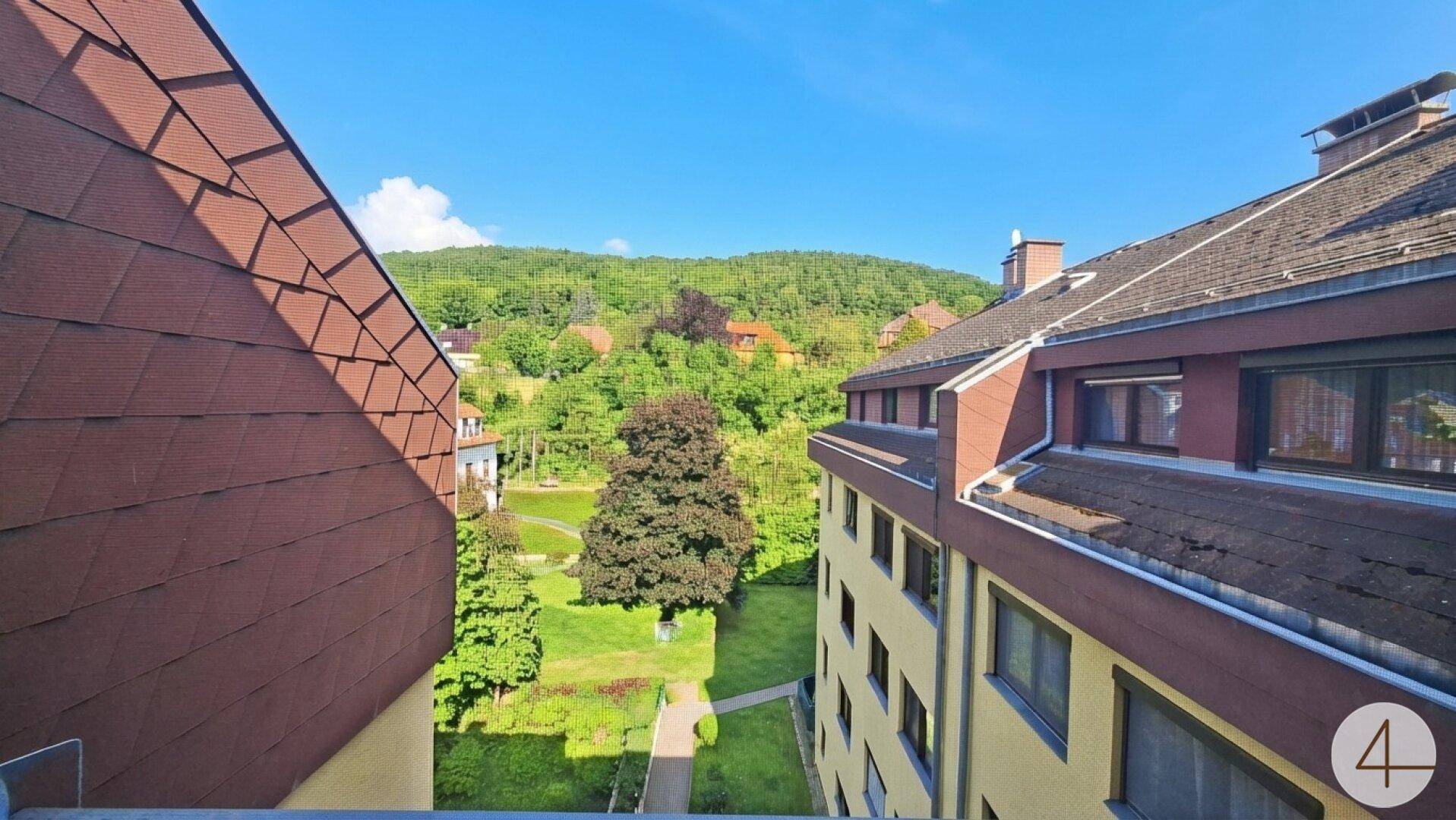 Malerischer Ausblick auf grüne Hügel und umliegende Gebäude von der Immobilie.