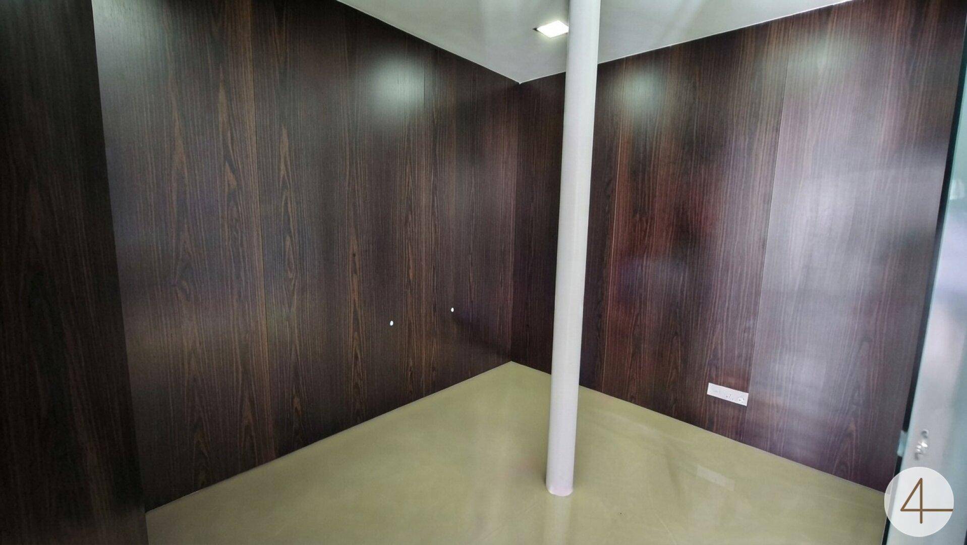 Kleiner Büroraum mit dunklen Holzwänden und hellem Boden, ideal für konzentriertes Arbeiten.
