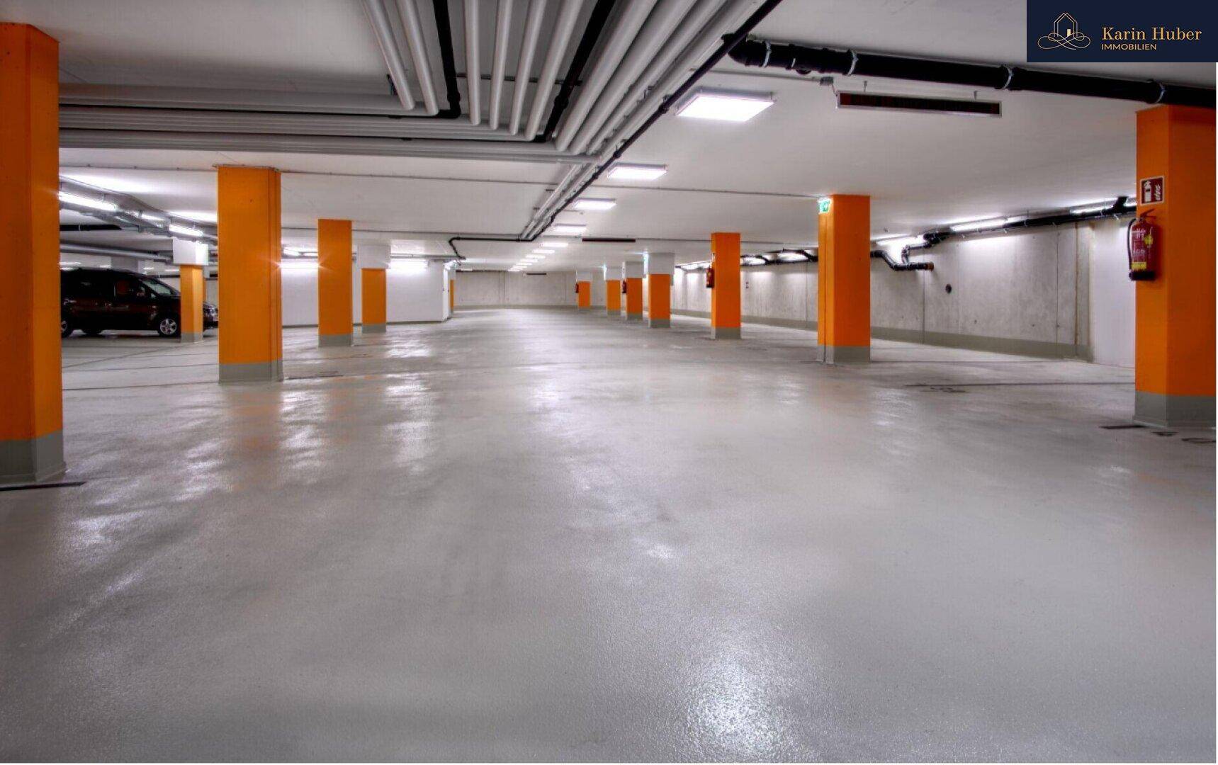 Geräumige Tiefgarage mit orangefarbenen Säulen und ausreichend Parkplätzen.