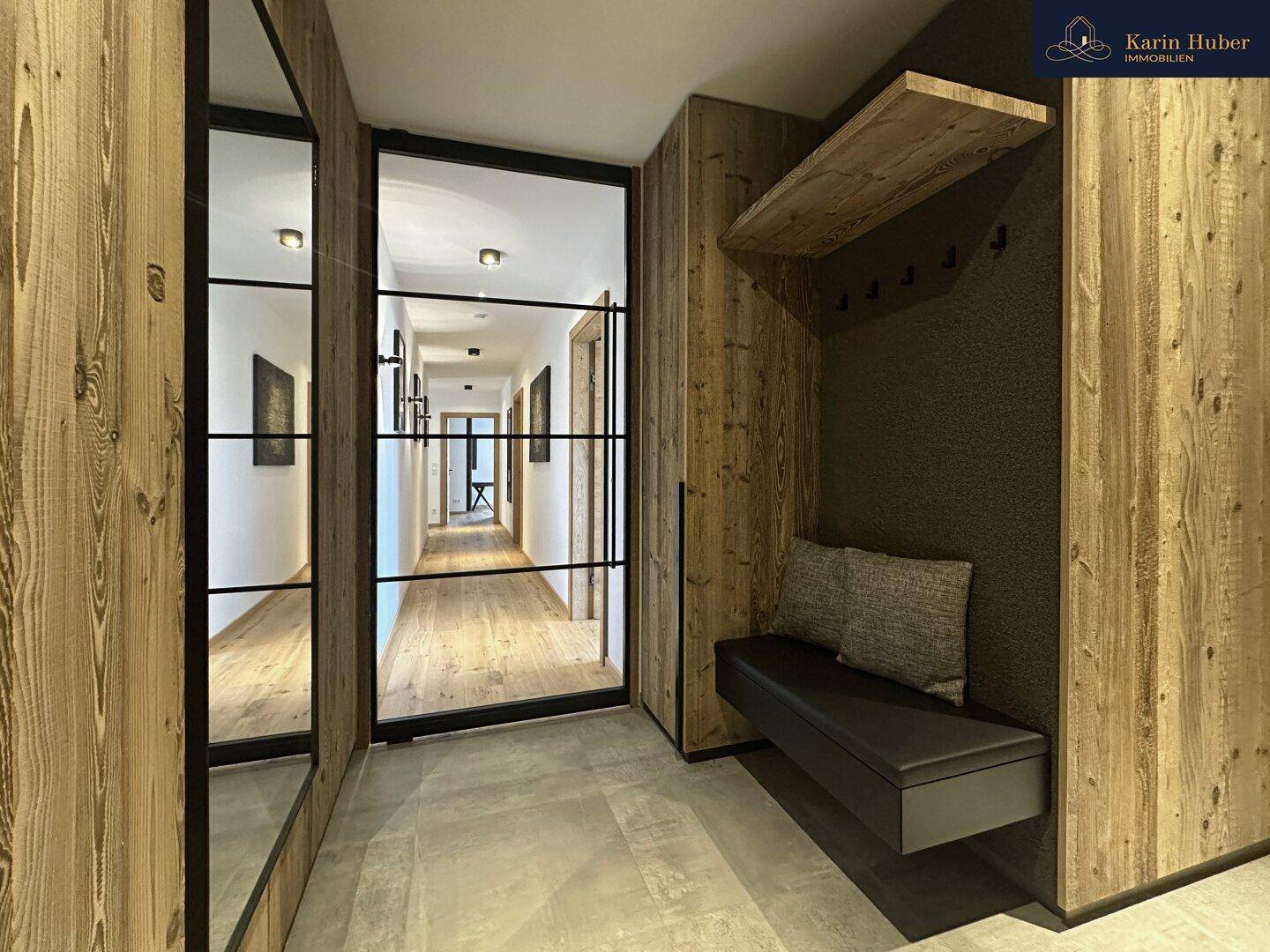 Moderner Eingangsbereich mit Holzwänden, Sitzbank und Garderobe.