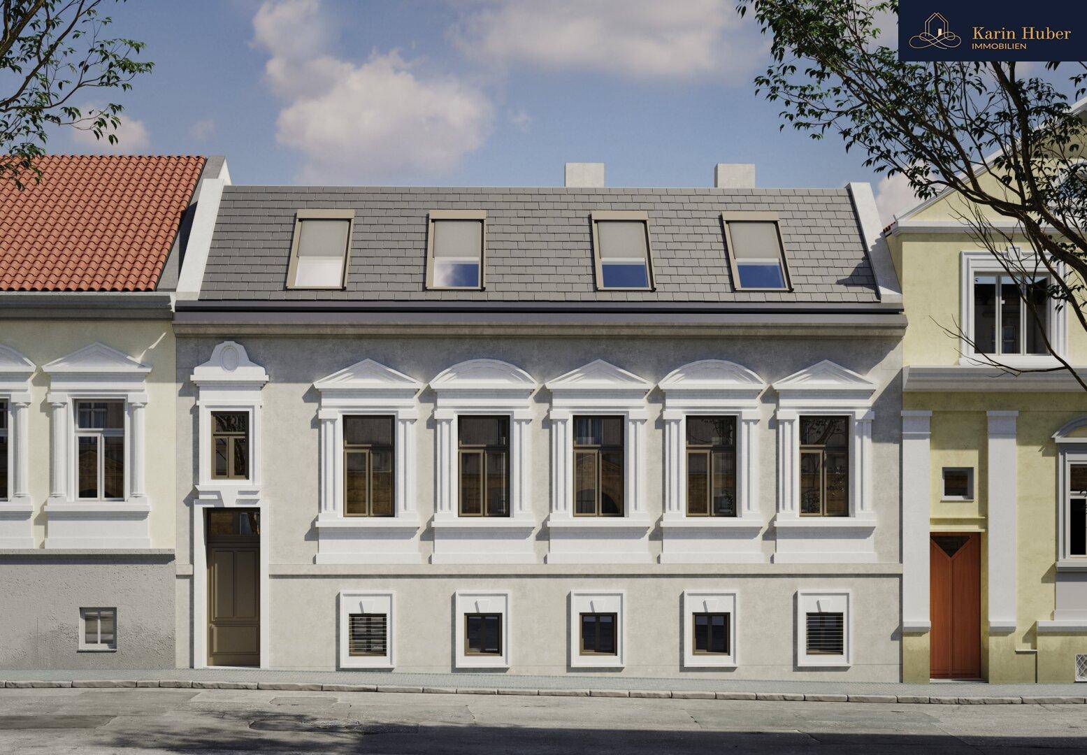 Klassische Fassade eines Stadthauses mit Mansarddach und vielen Fenstern.