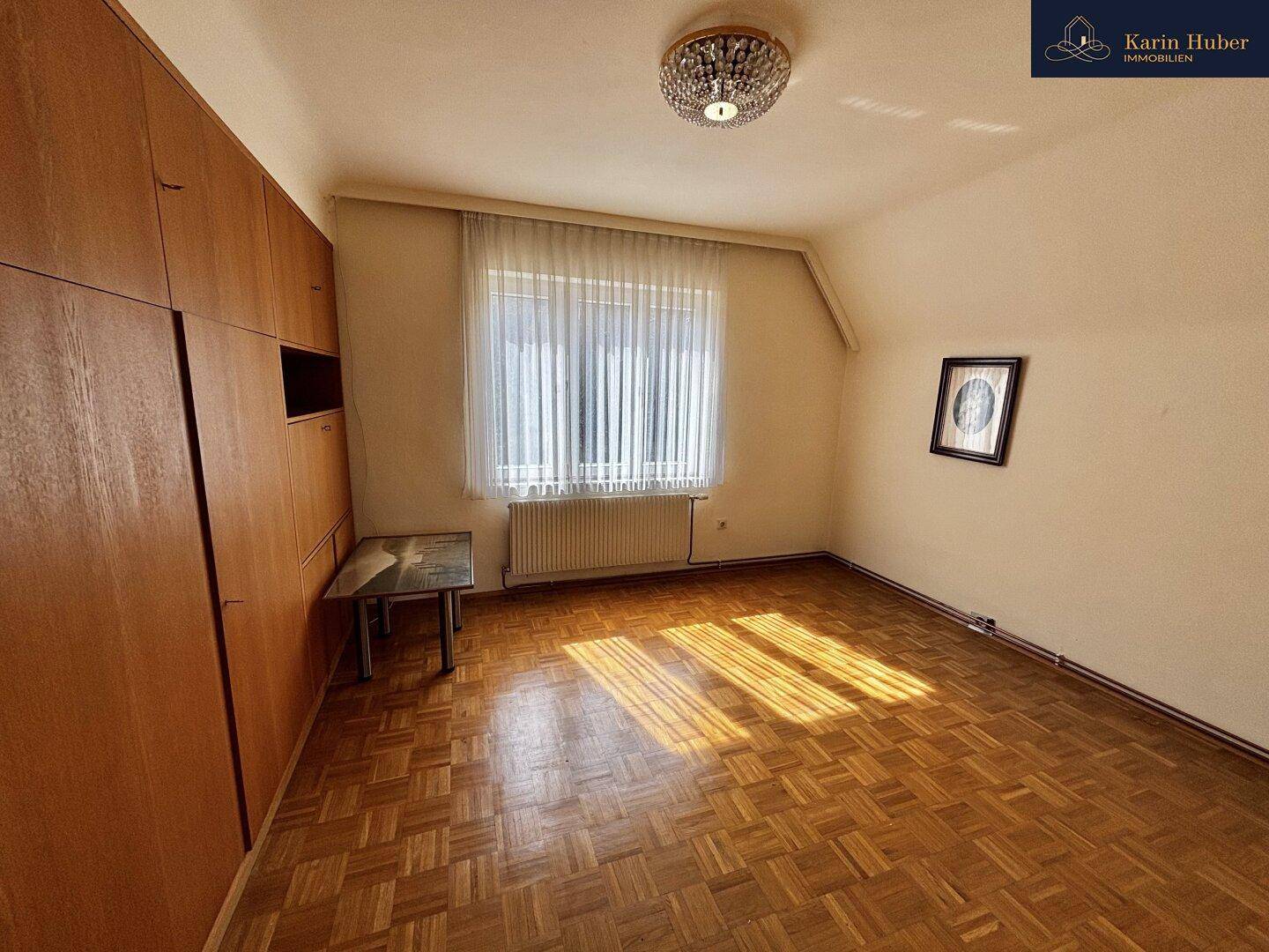 Geräumiges Schlafzimmer mit Einbauschränken, Parkettboden und viel natürlichem Licht.