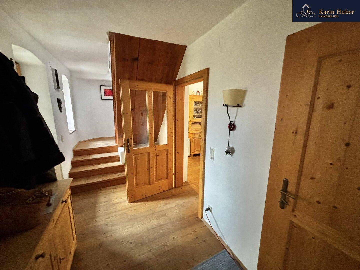 Flur mit Holzboden und Treppe, der zu weiteren Räumen führt.