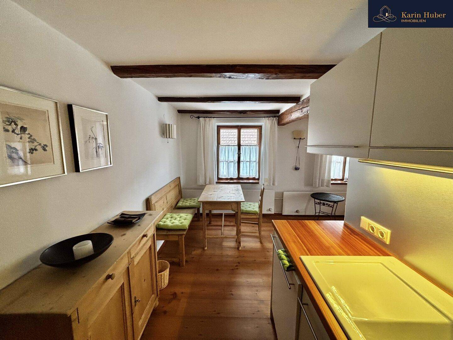 Gemütliche Wohnküche mit Holzboden, Essbereich und einer modernen Küchenzeile.