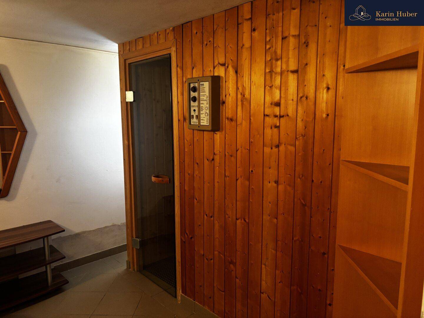 Wellnessbereich mit holzverkleideter Sauna und Regalen für Entspannung.