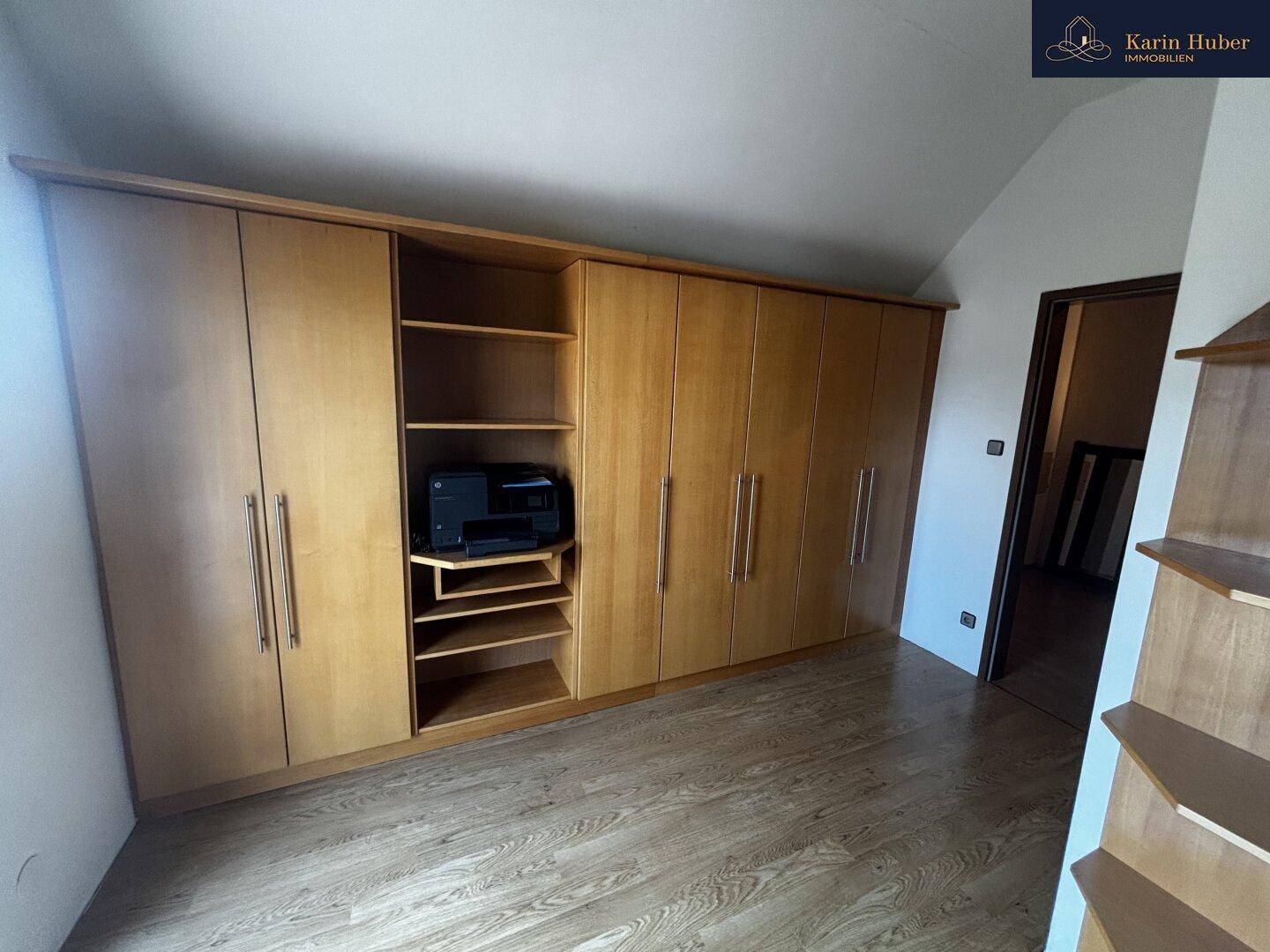 Schlafzimmer mit Einbauschränken und Laminatboden, bietet viel Stauraum.