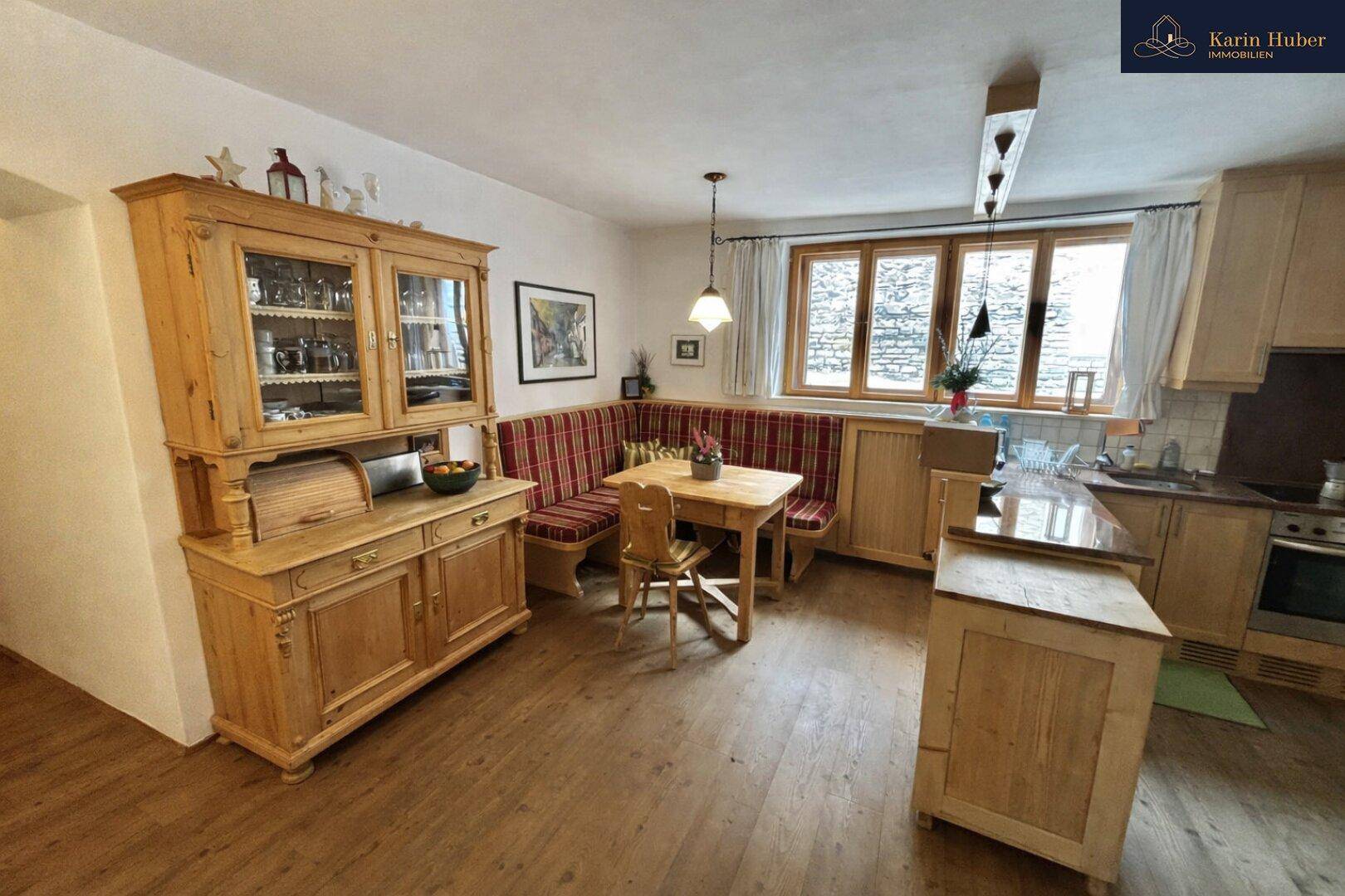 Rustikale Wohnküche mit Holzboden, traditionellen Holzmöbeln und einer gemütlichen Eckbank.