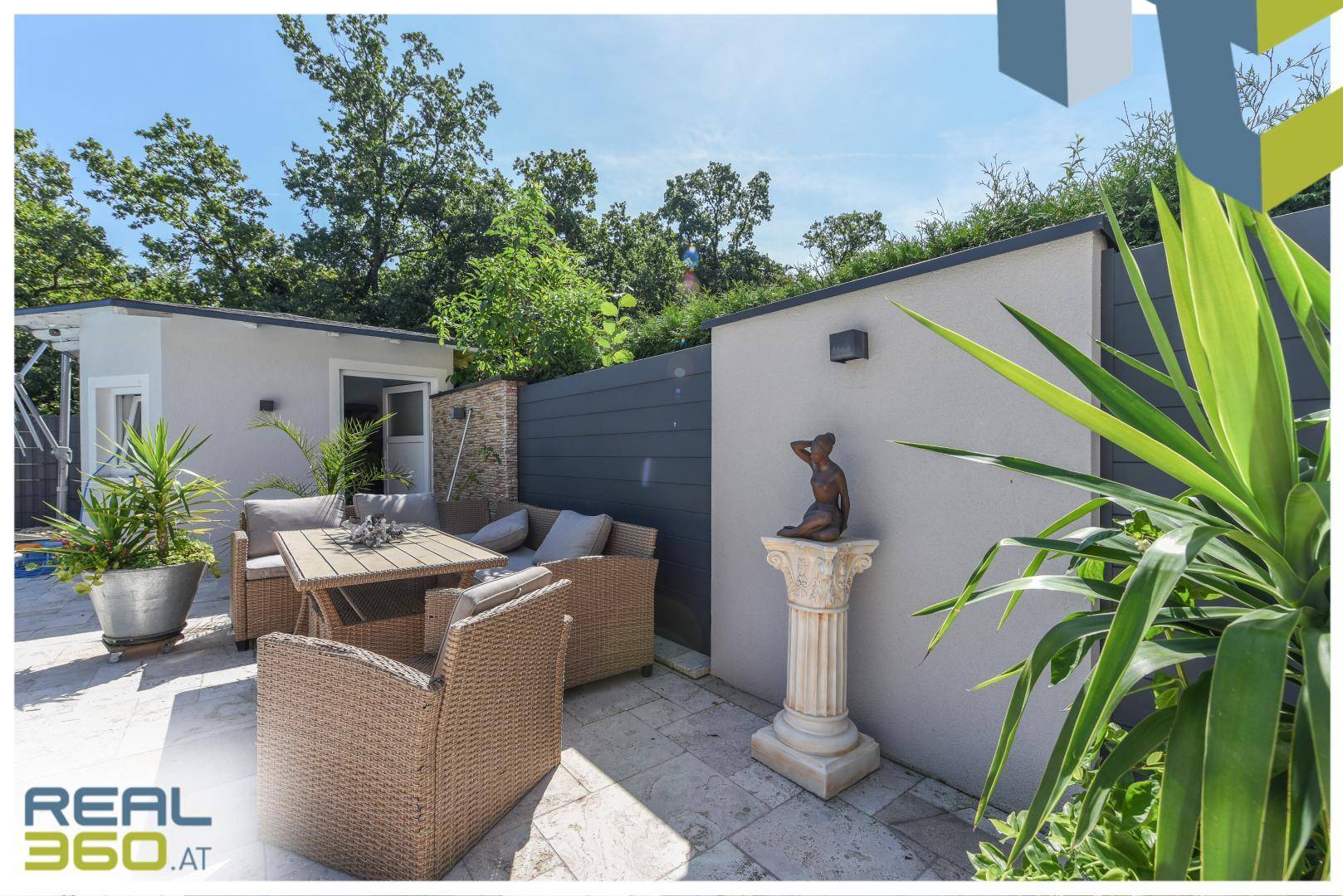 Blick auf die Terrasse und das Poolhaus