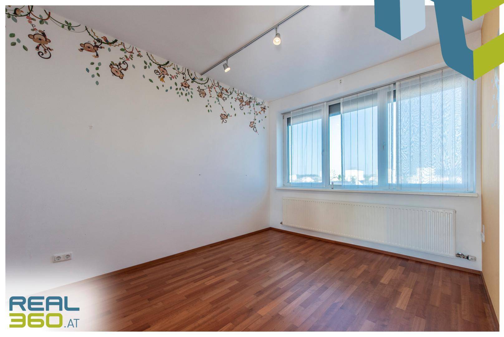 Helles Schlafzimmer mit Parkettboden und großem Fenster, bereit zur individuellen Gestaltung.