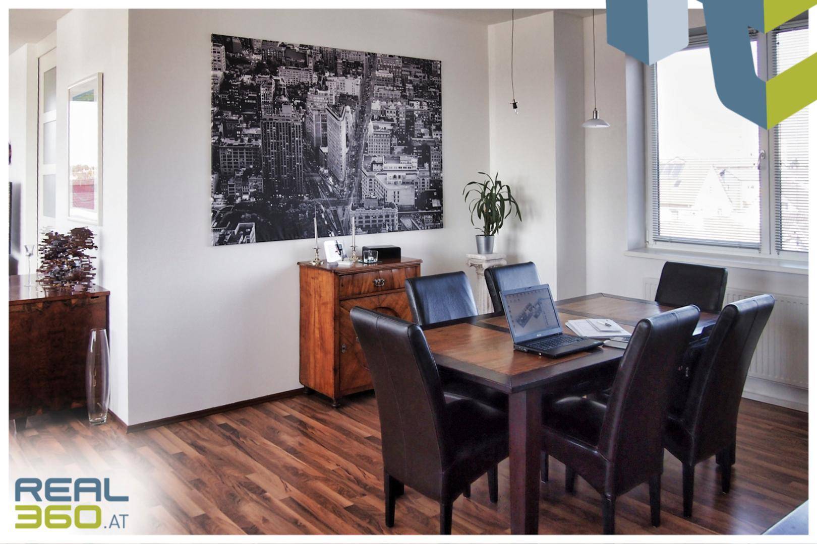 Eleganter Essbereich mit Holztisch, Lederstühlen und einem großen Wandbild.