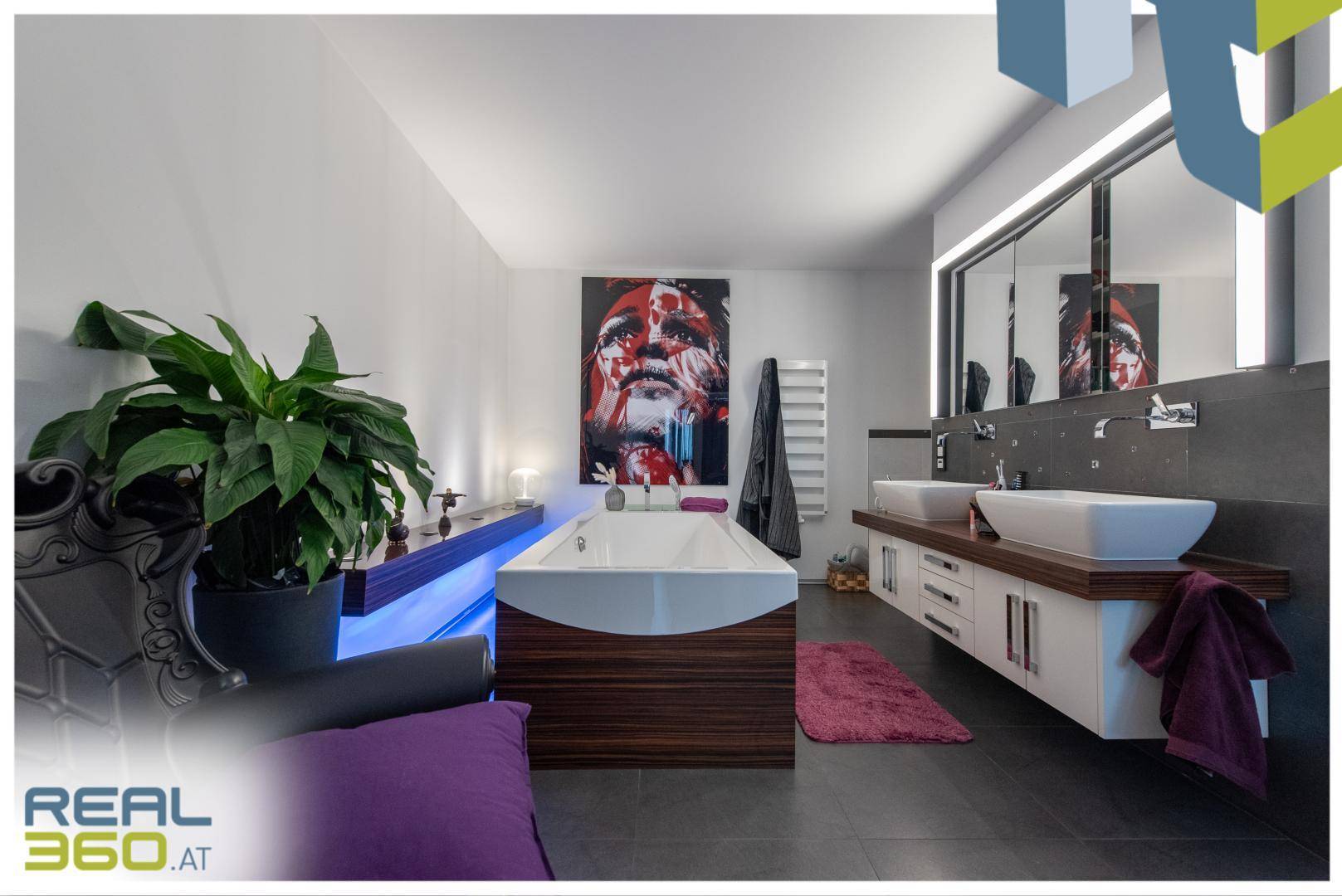 Luxuriöses Badezimmer mit freistehender Badewanne, Doppelwaschbecken und moderner Beleuchtung.