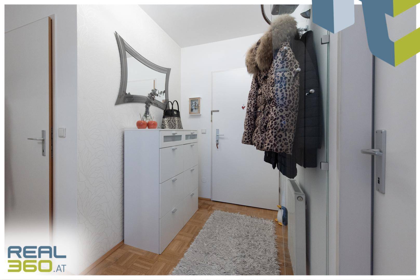 Heller Eingangsbereich mit Schuhschrank, Garderobe und Parkettboden.