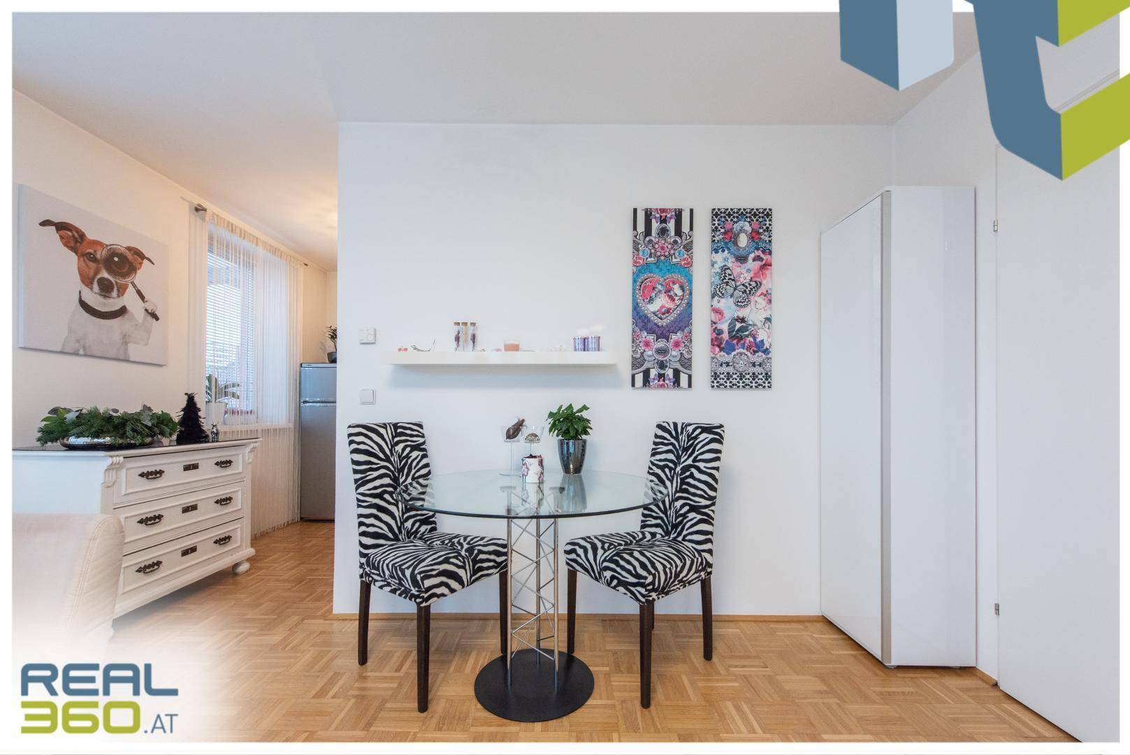Kleiner Essbereich mit modernem Glastisch und gemusterten Stühlen.