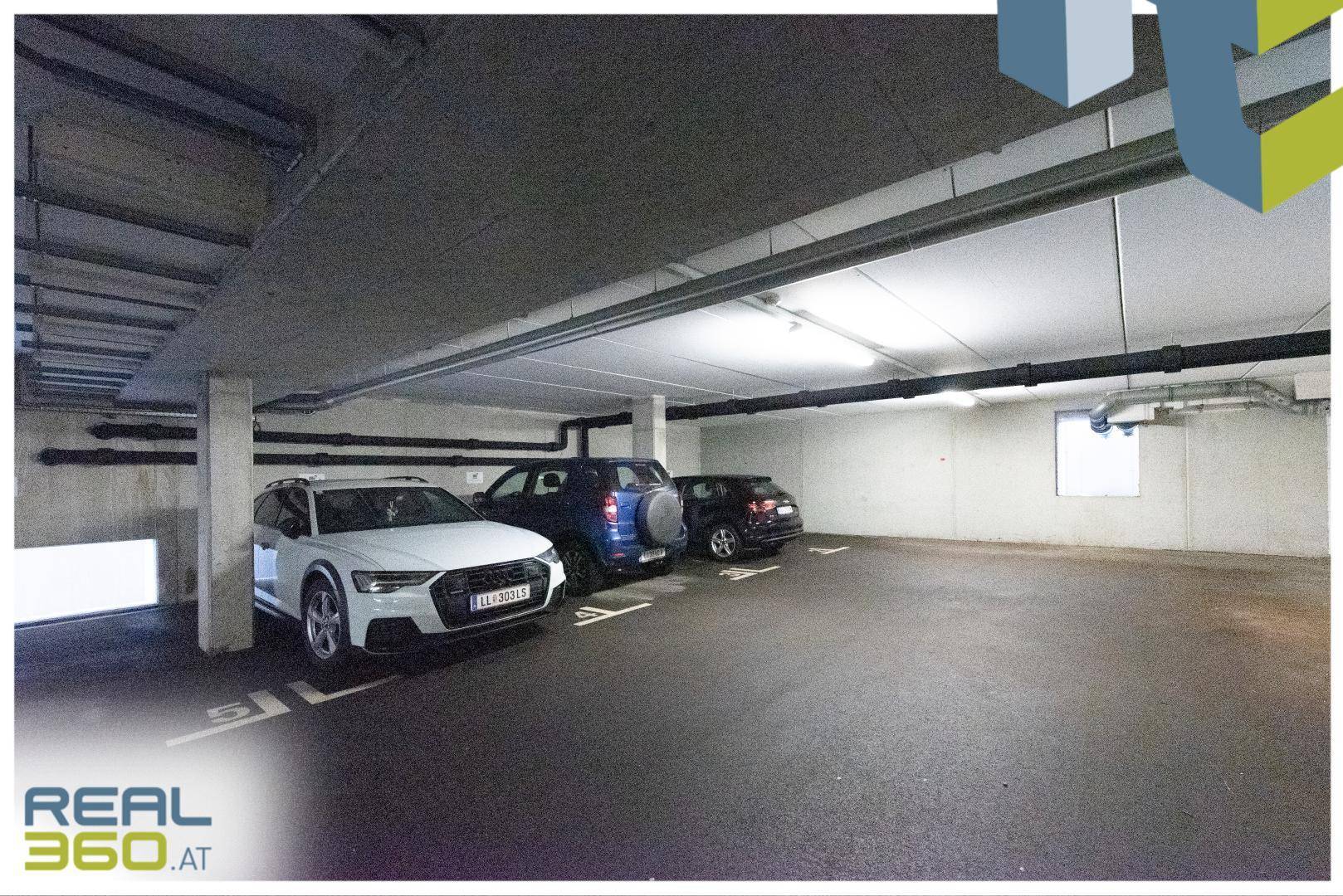 Tiefgarage mit mehreren geparkten Autos und Betonwänden, bietet sichere Stellplätze.