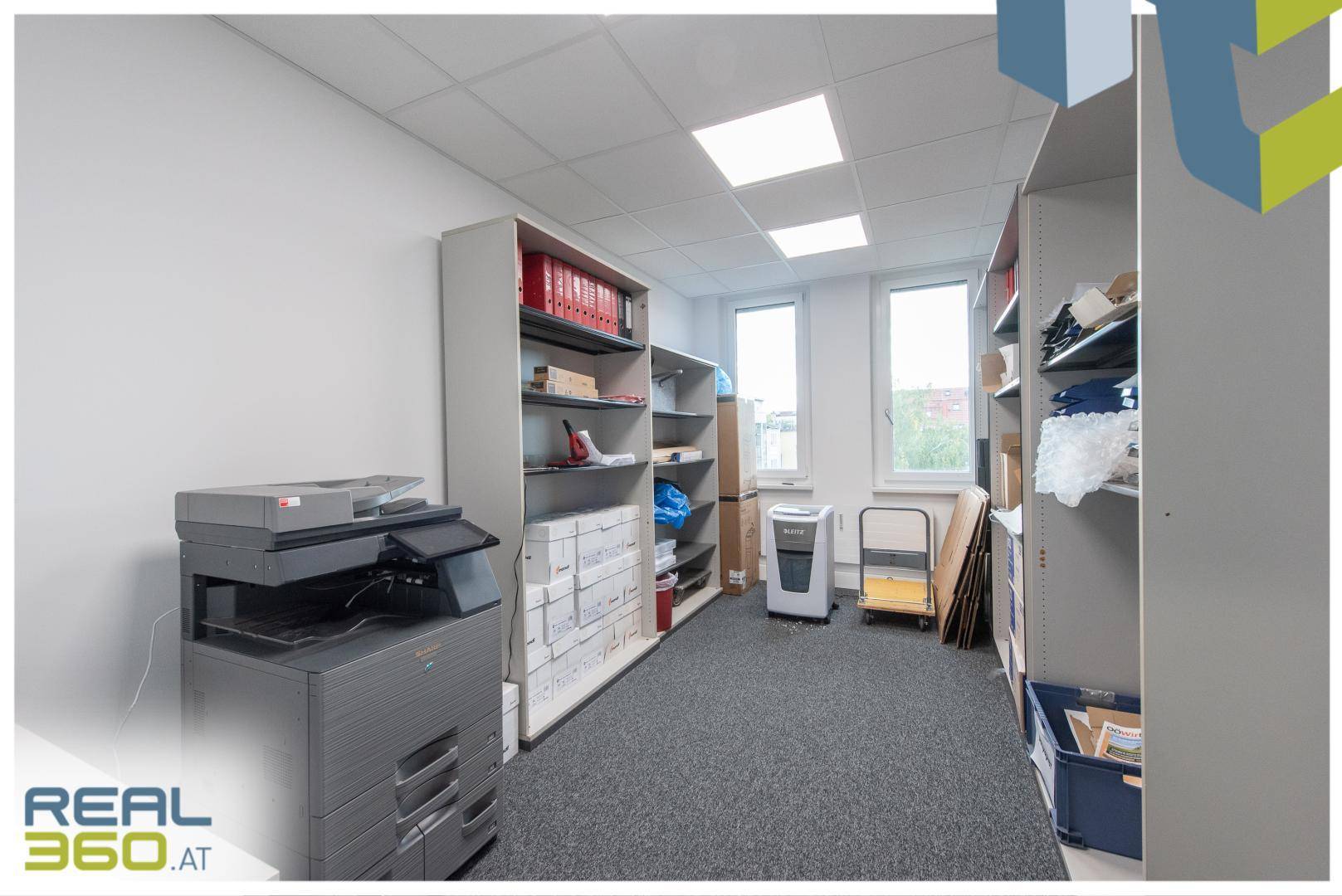Funktionaler Abstellraum mit Regalen, Kopierer und Aktenvernichter, ideal für Bürobedarf.