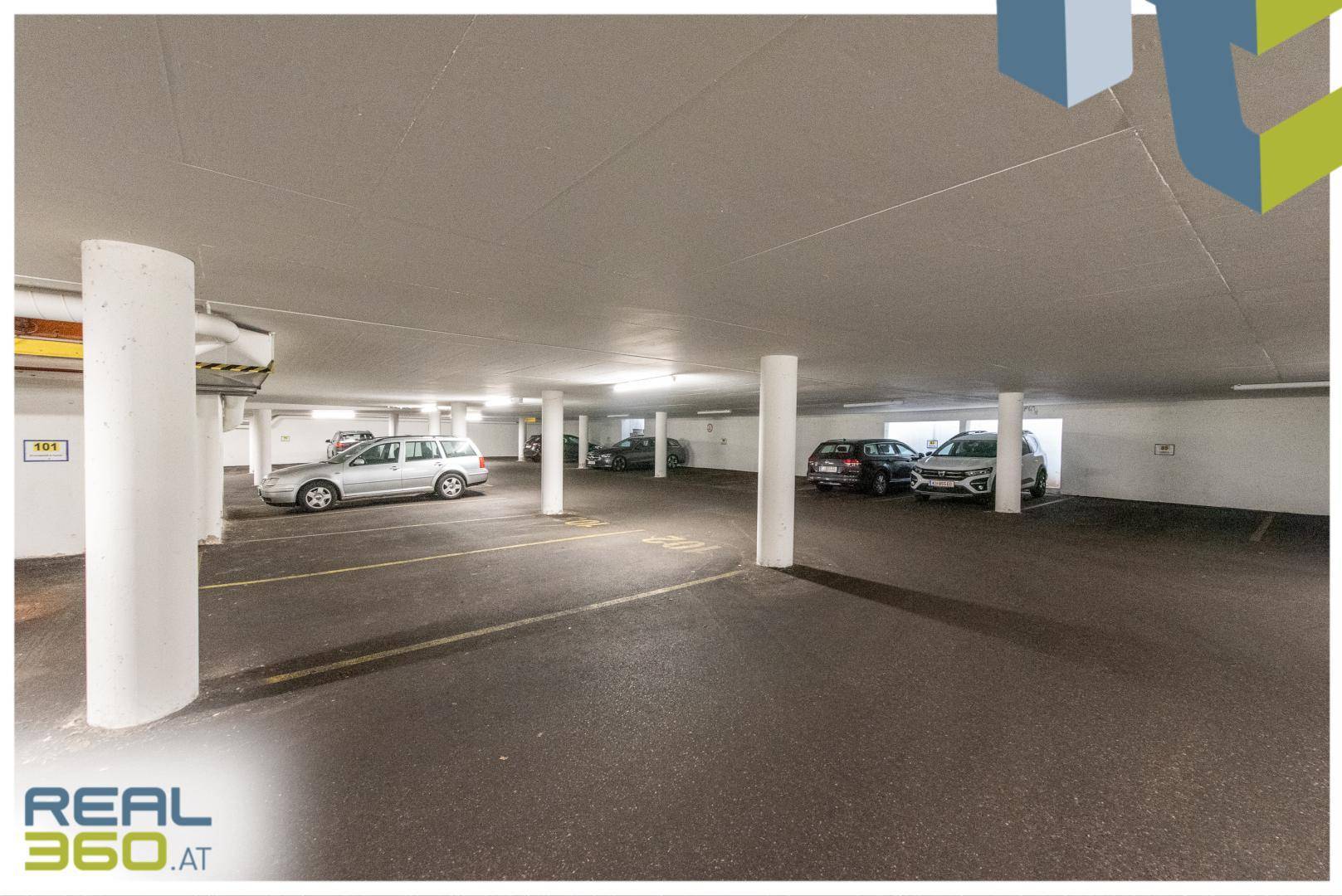 Tiefgarage mit mehreren Stellplätzen, Säulen und Beleuchtung, ideal für Fahrzeuge.