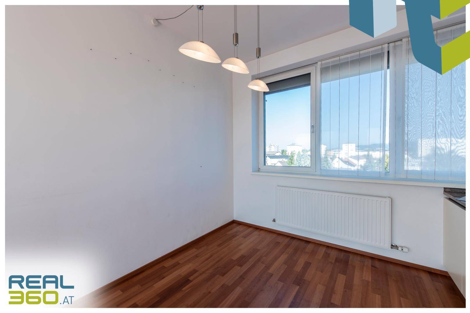 Heller Essbereich mit Parkettboden und Fenster, bereit für eine individuelle Gestaltung.