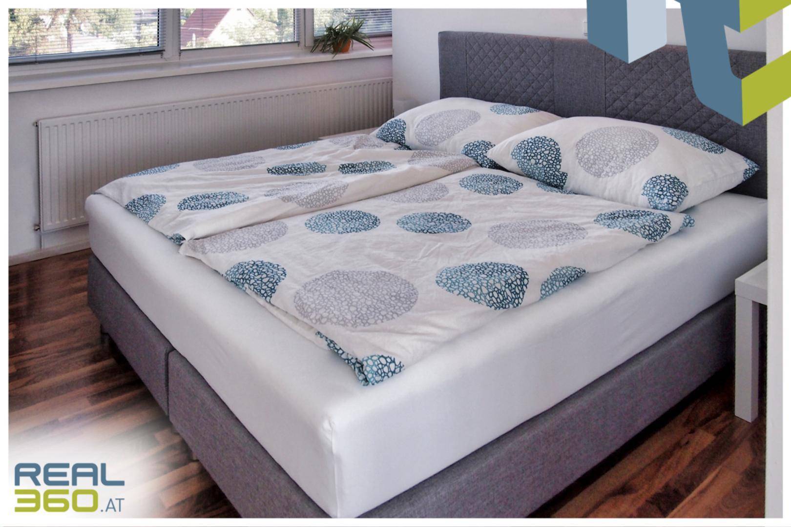 Gemütliches Schlafzimmer mit Doppelbett und Fenster für natürliches Licht.