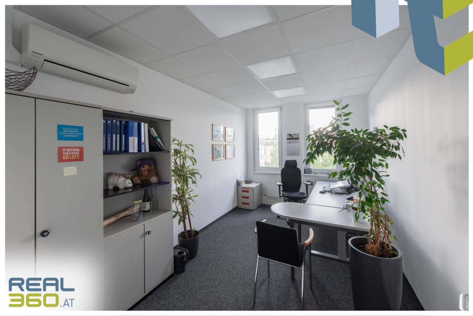 Büro mit Schreibtisch, Bürostuhl, Schränken und Klimaanlage an der Wand für angenehmes Raumklima.