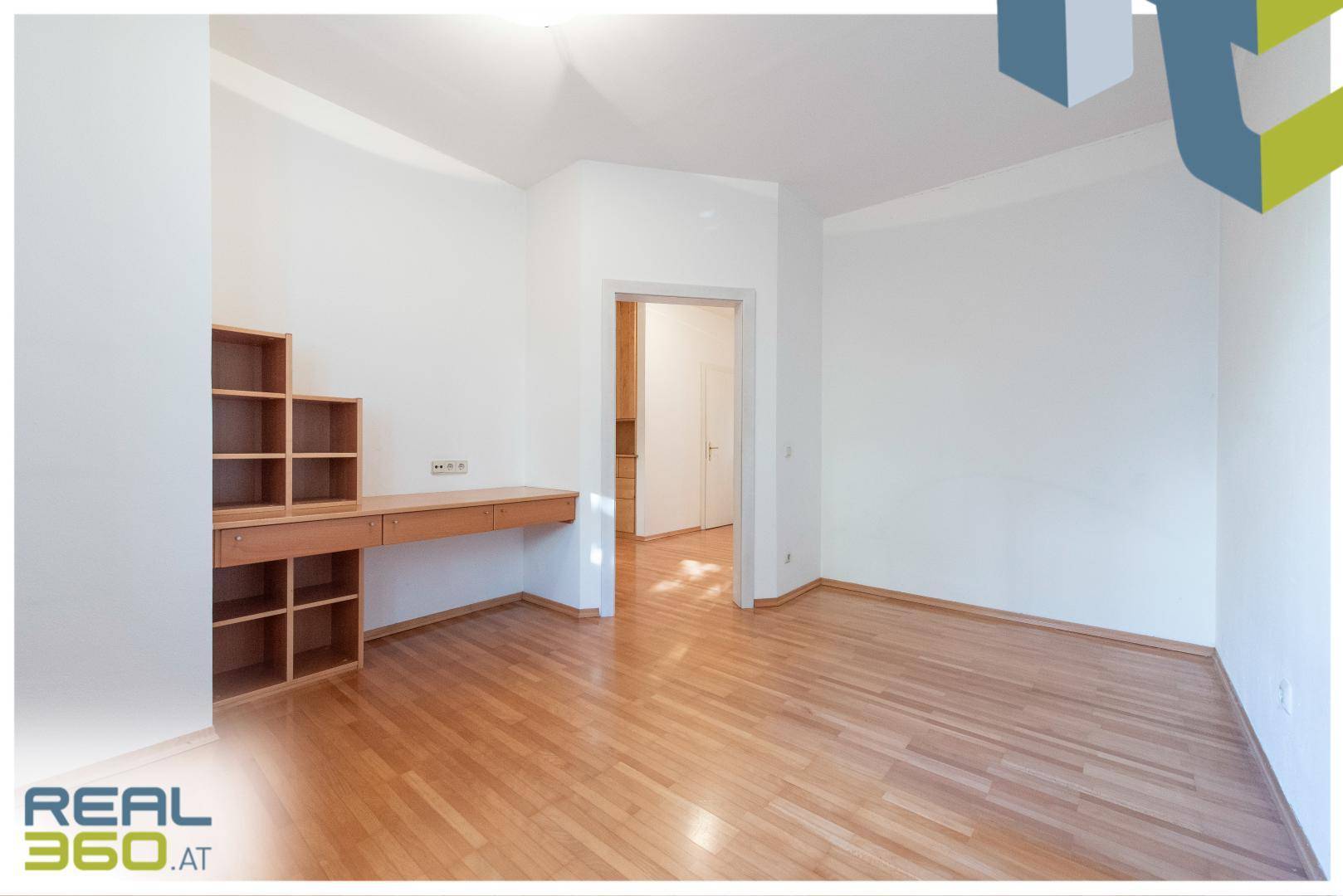 Geräumiges Zimmer mit Parkettboden und Einbaumöbeln, ideal als Schlaf- oder Arbeitszimmer.