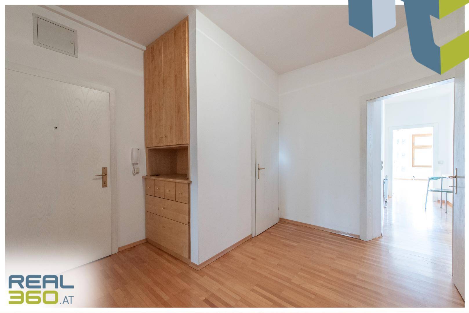 Eingangsbereich mit Parkettboden, Einbauschrank und Zugang zu weiteren Räumen.