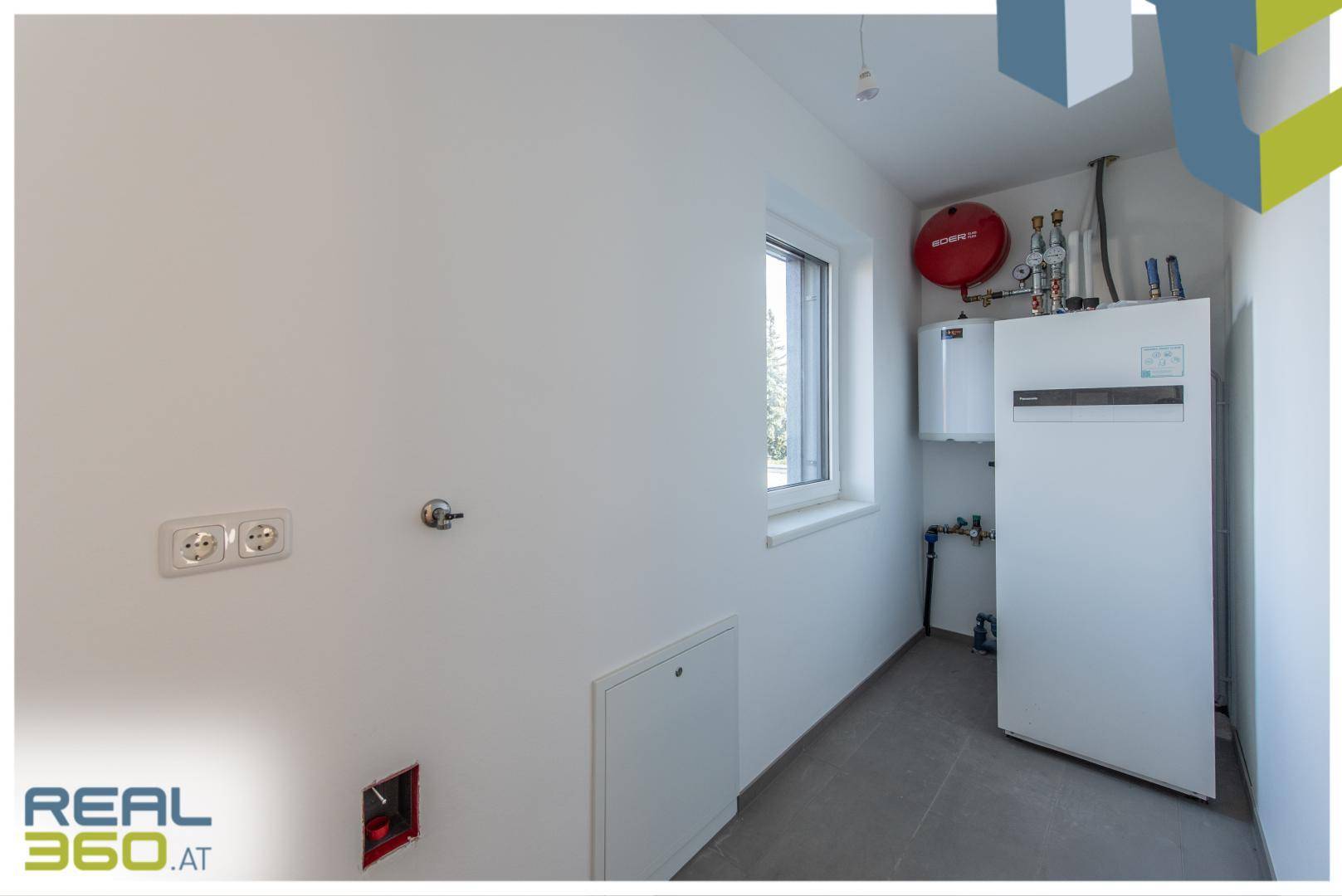 Hauswirtschaftsraum mit Heizungsanlage, Warmwasserspeicher und Fenster.