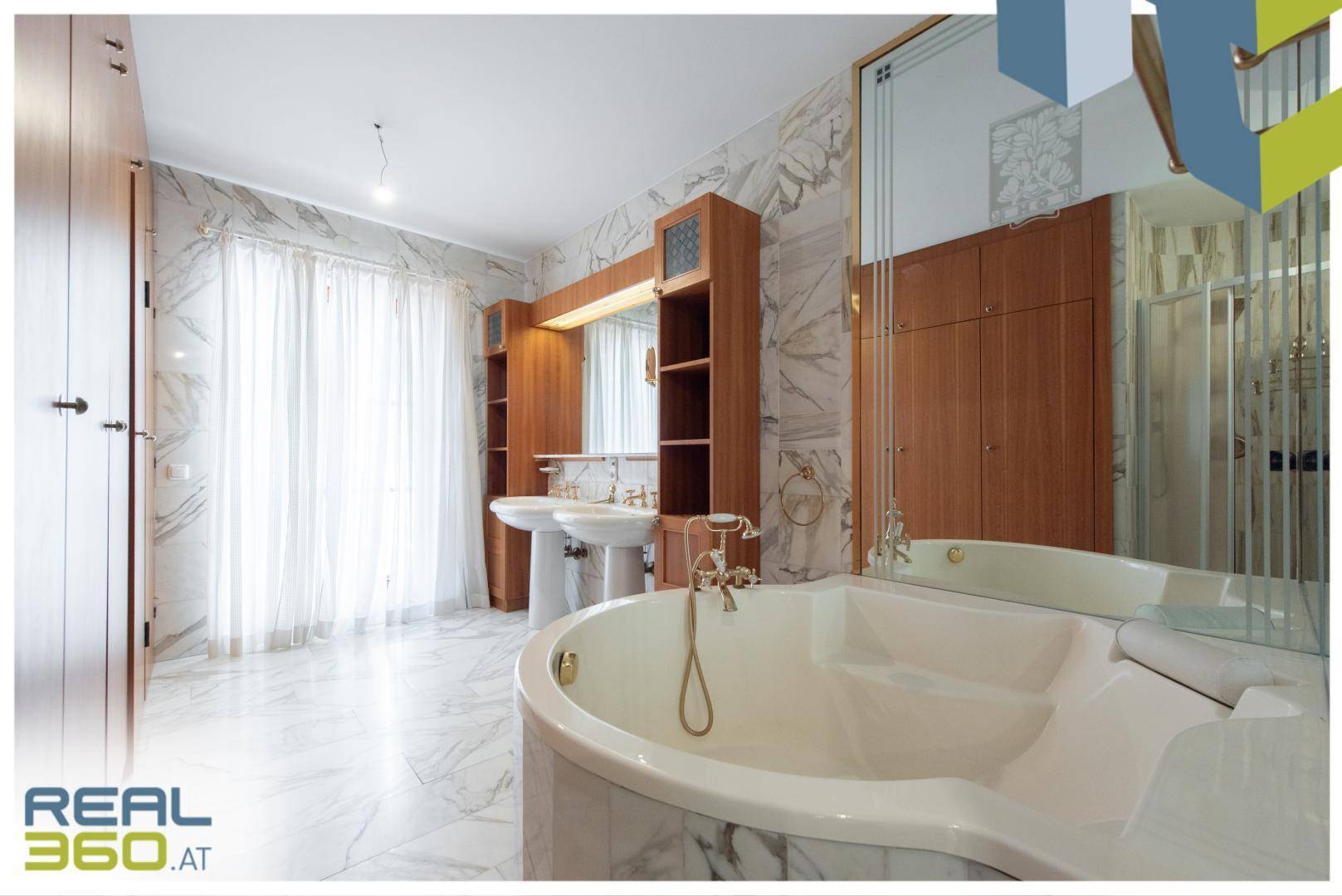 Großes Badezimmer mit Eckbadewanne, Doppelwaschbecken und Marmorfliesen für luxuriöses Ambiente.