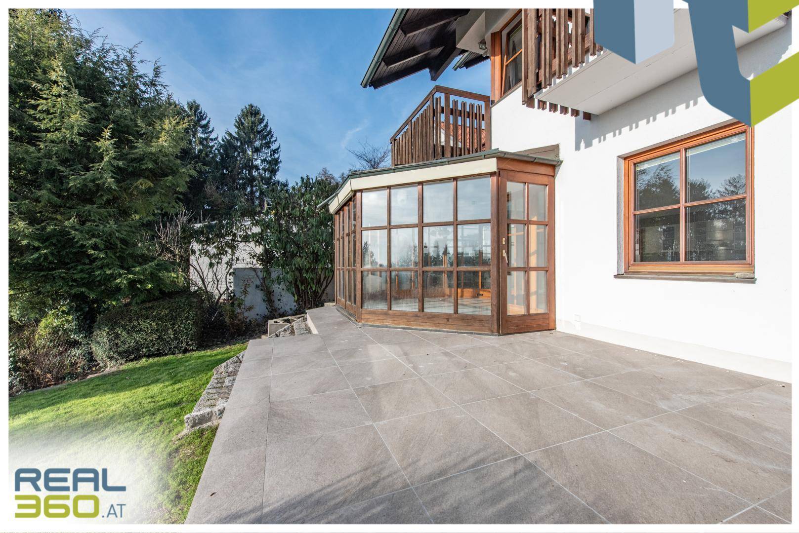 Große geflieste Terrasse neben dem Wintergarten mit Zugang zum Garten.