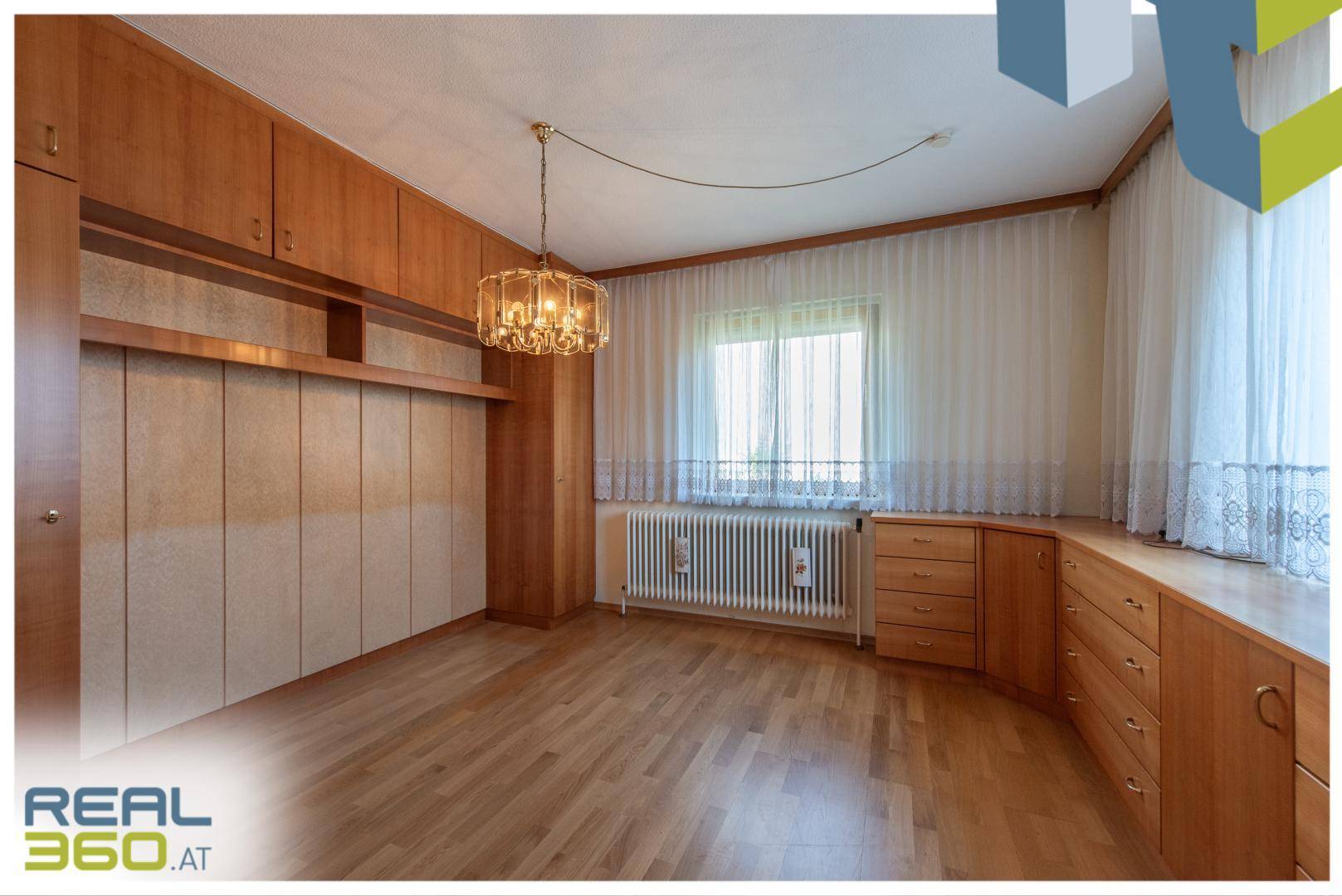 Geräumiges Schlafzimmer mit Holzparkett, großen Fenstern und Einbauschränken.